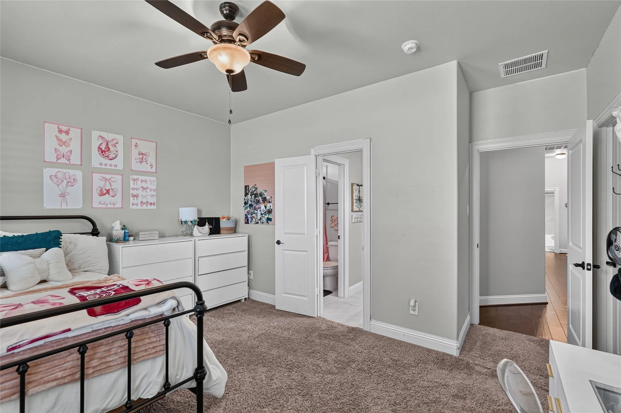 Carpeted flooring, ceiling fan with integrated lighting, multiple doorways, and light gray wall paint
