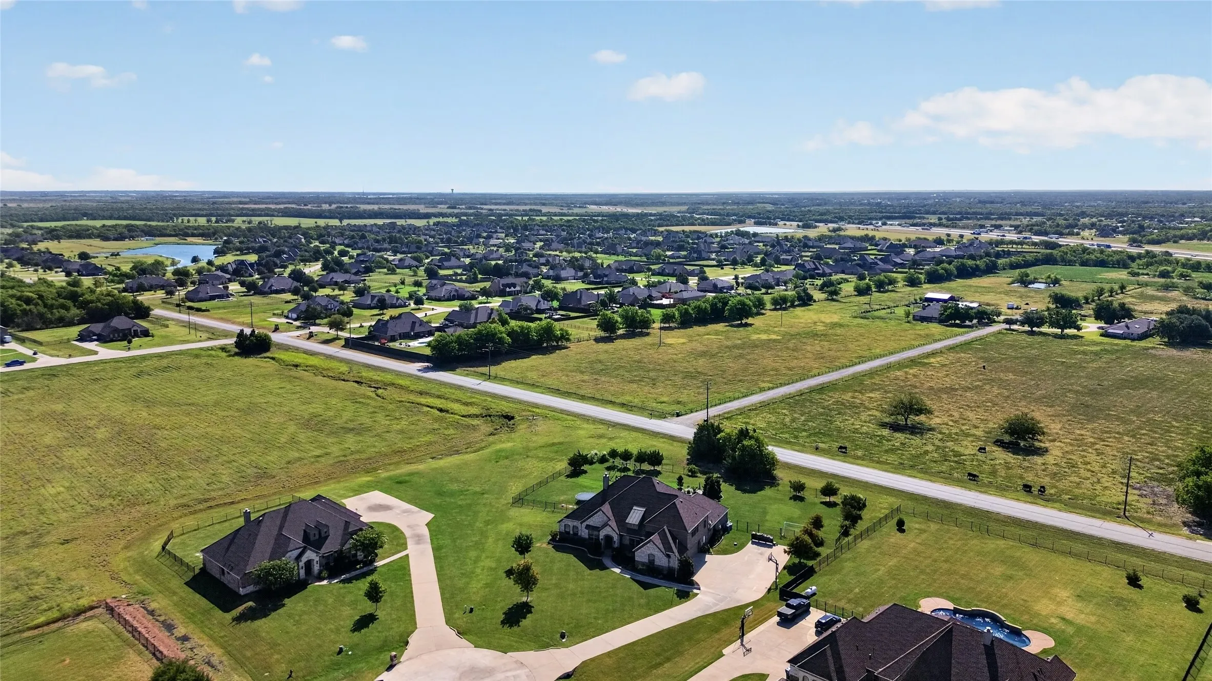 Expansive residential community featuring multiple custom homes situated on generous manicured lots
