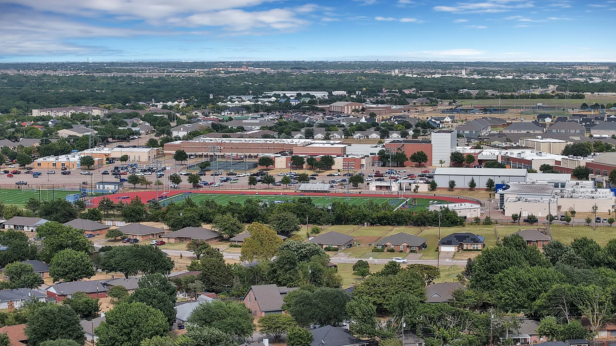 Expansive neighborhood with mature trees, residential properties, and institutional buildings
