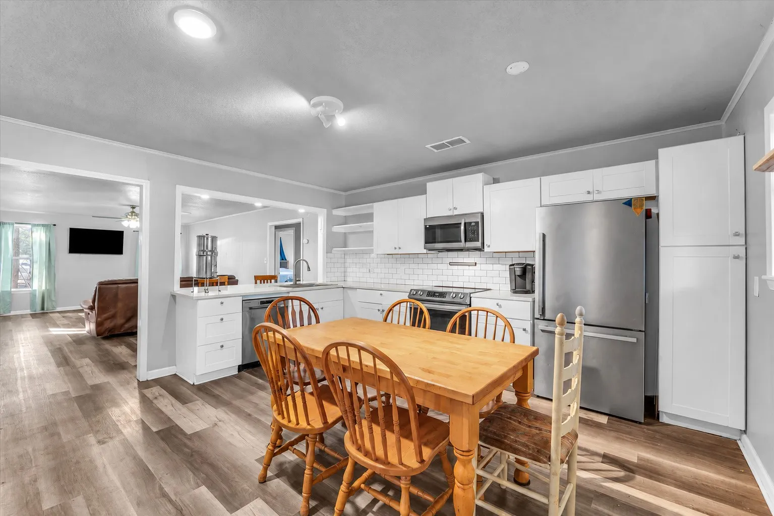 White shaker cabinetry with stainless steel appliances, subway tile backsplash, and recessed lighting