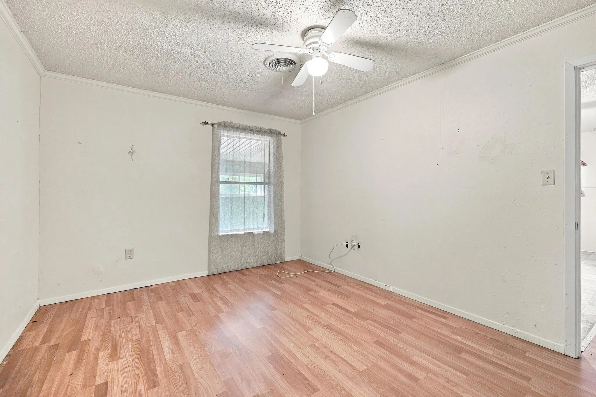 Recessed window with sheer curtain, wood-finish flooring, white walls, and a ceiling fan with light fixture