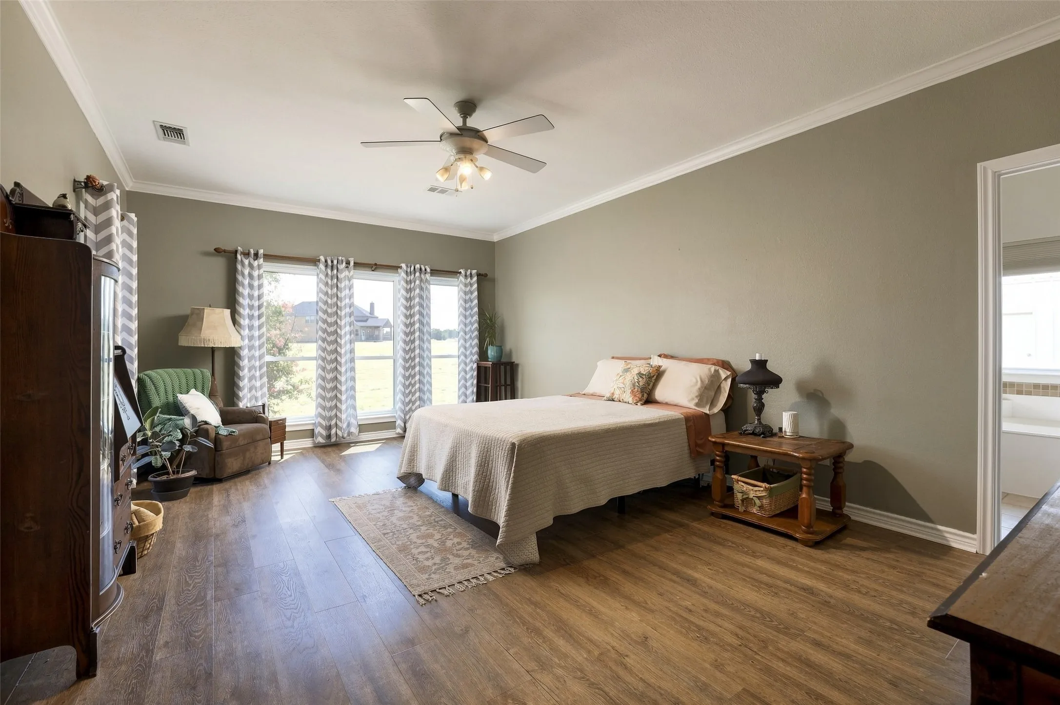 The large primary bedroom is filled with natural light