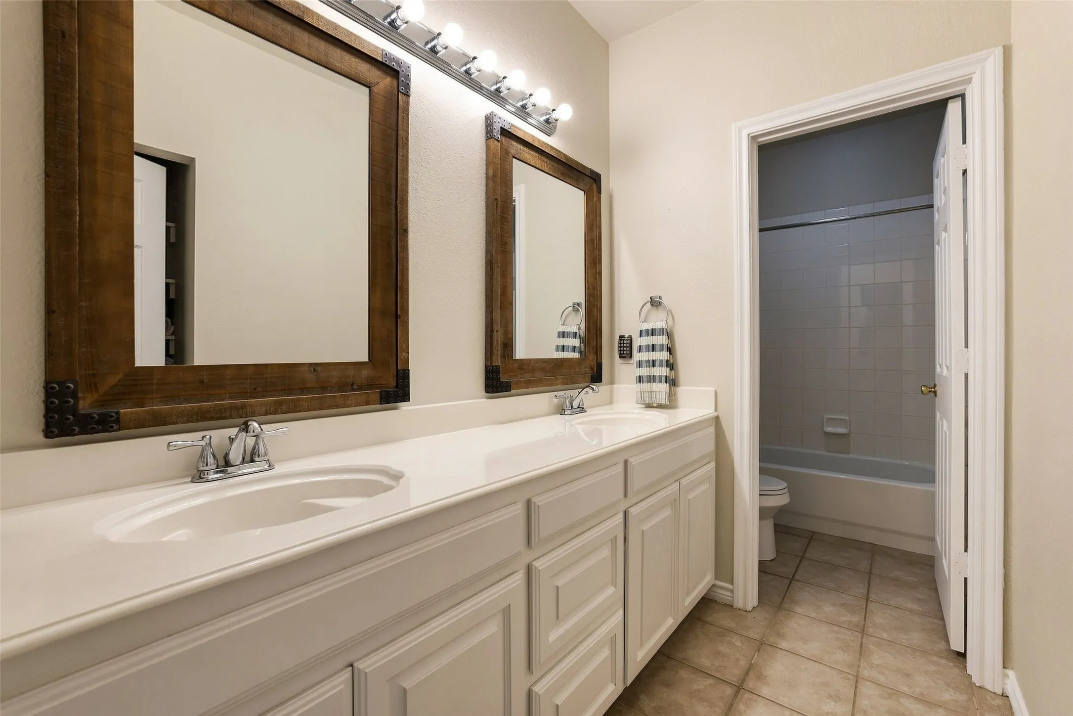 Full guest bath has a large vanity, separate linen storage and separate wet space for privacy