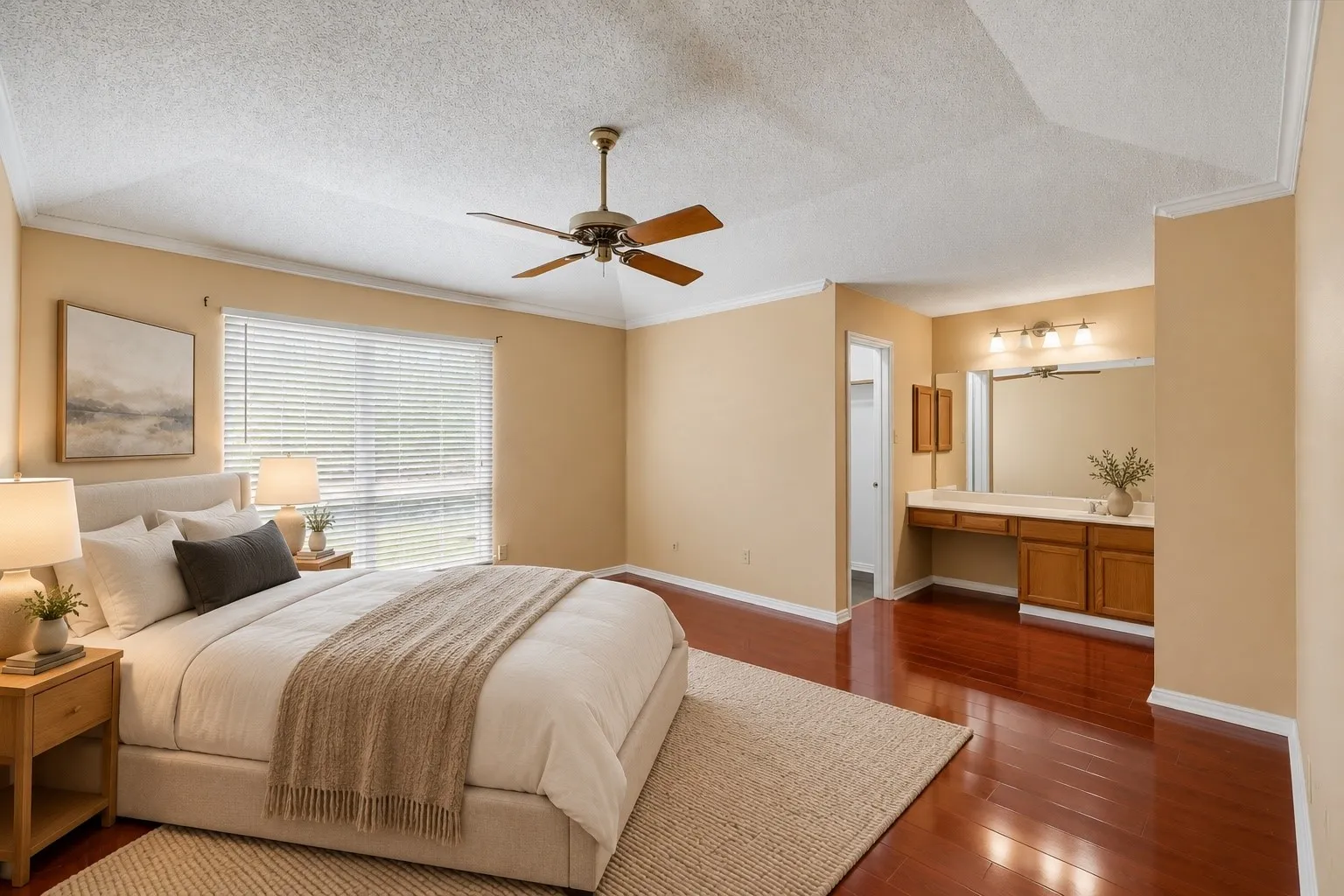 Vaulted ceiling with a ceiling fan, crown molding, large window with blinds, wood-finish flooring, and built-in vanity with wood cabinetry