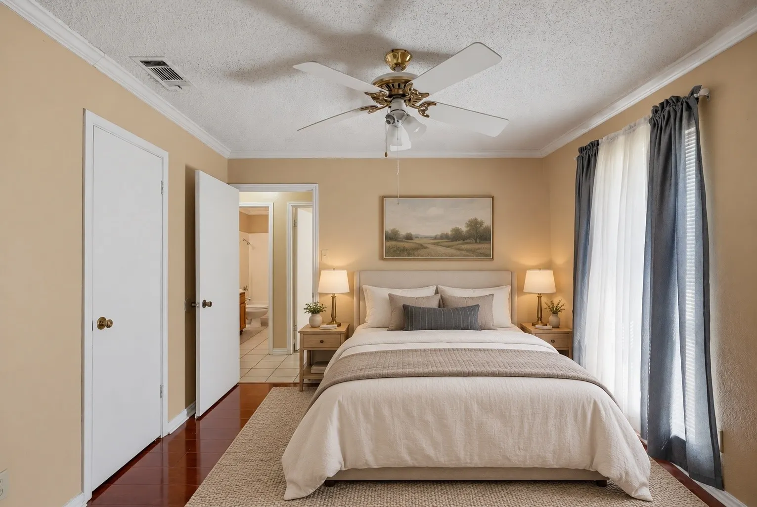 Serene primary bedroom showcasing warm neutral walls, hardwood flooring, and soft ambient lighting from dual bedside sconces