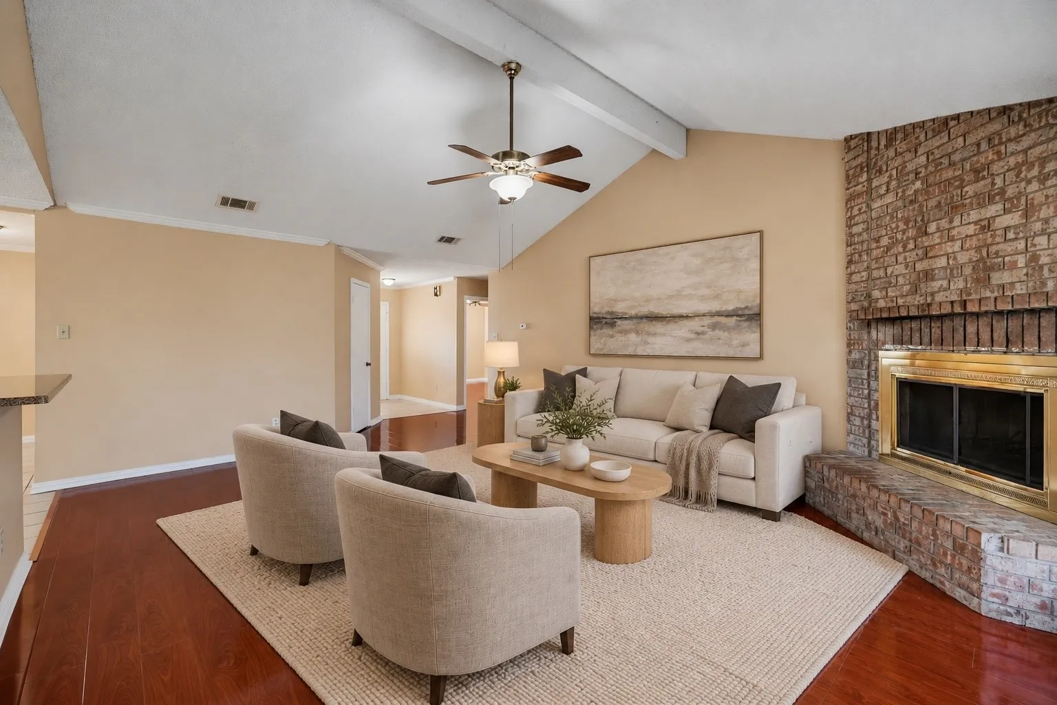 Wood-finish flooring throughout, vaulted ceiling with exposed beam, and a ceiling fan