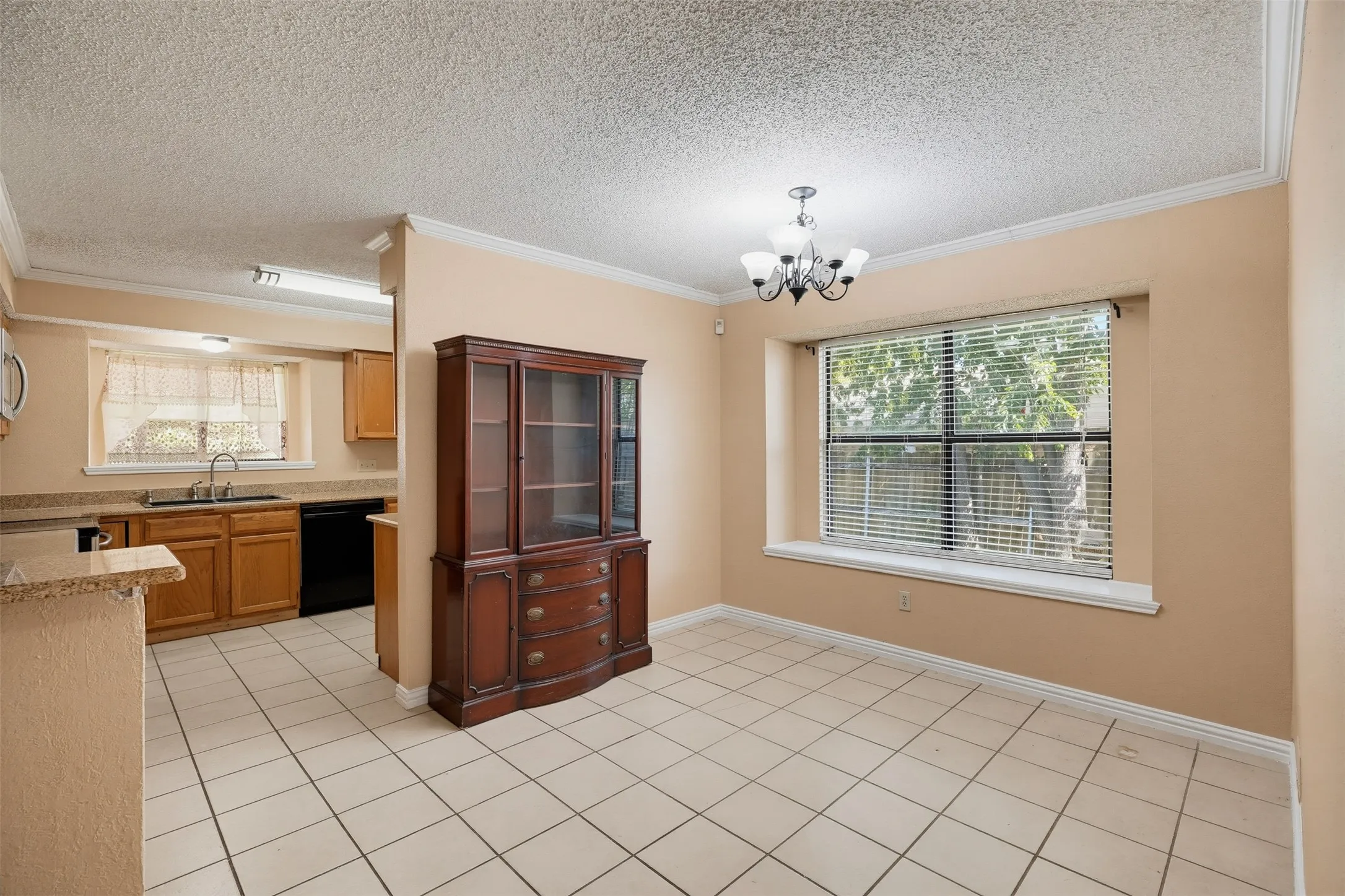 Ceramic tile flooring, crown molding, a large window with blinds, and a chandelier with glass shades
