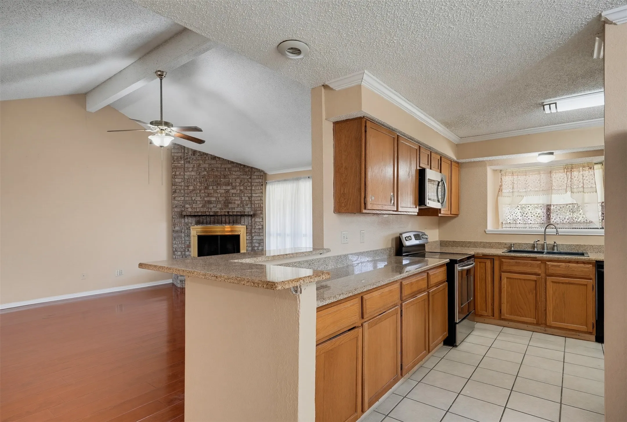 Kitchen featuring wood cabinetry, granite-finish countertops, and a stainless steel oven