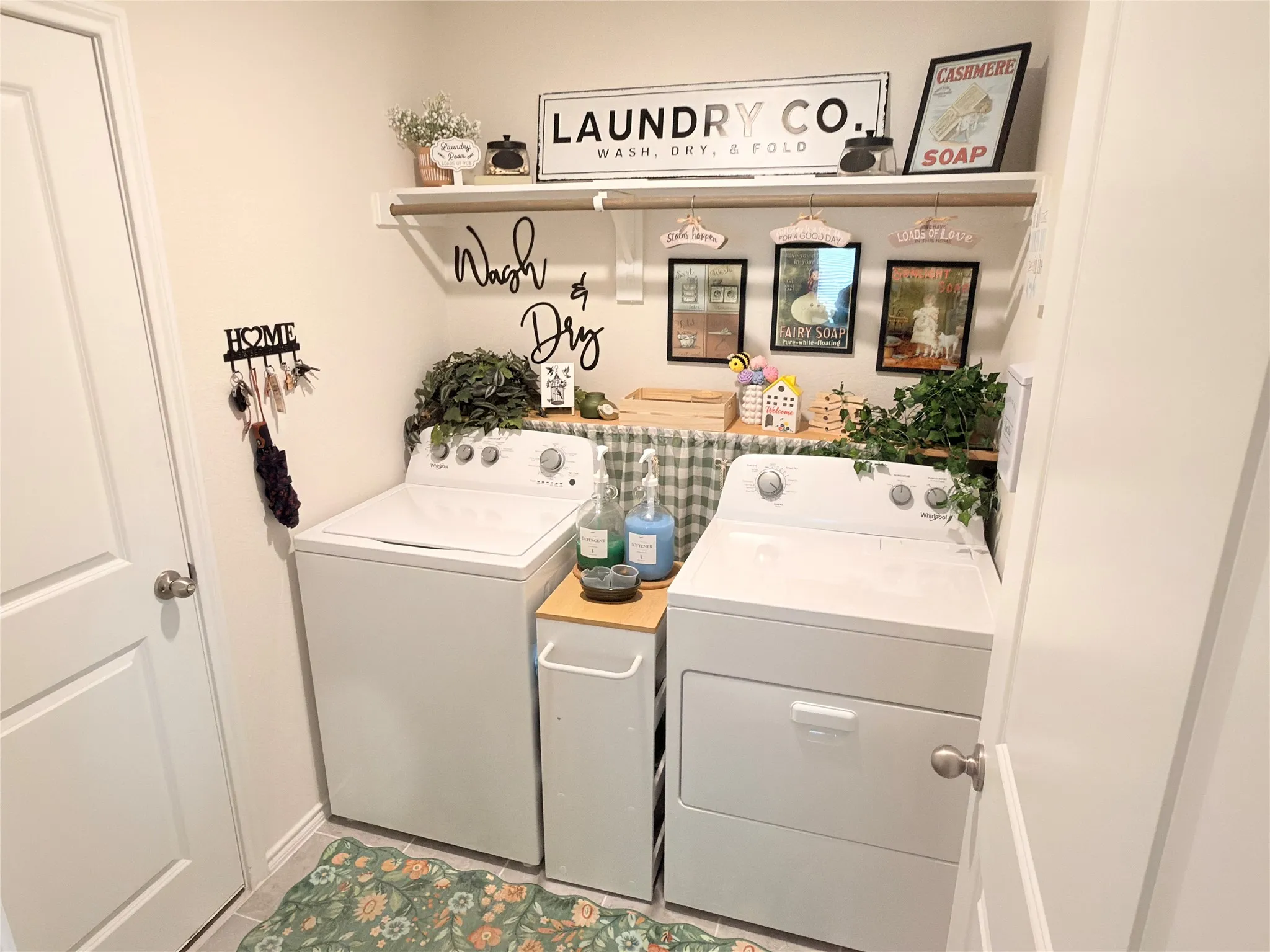 Compact laundry area featuring a built-in shelf, hanging rod, and light-toned walls