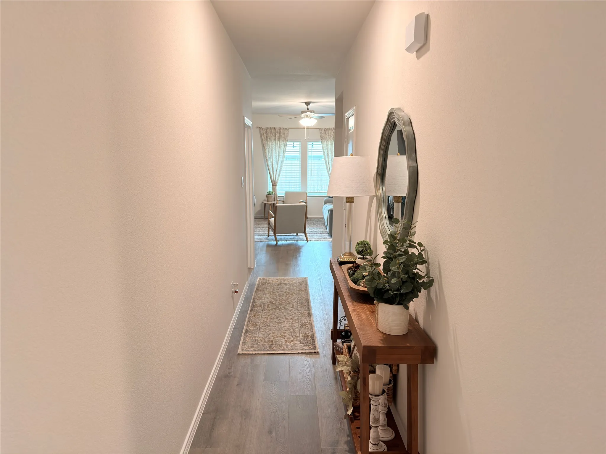Hallway featuring wood-finish flooring and light-toned walls