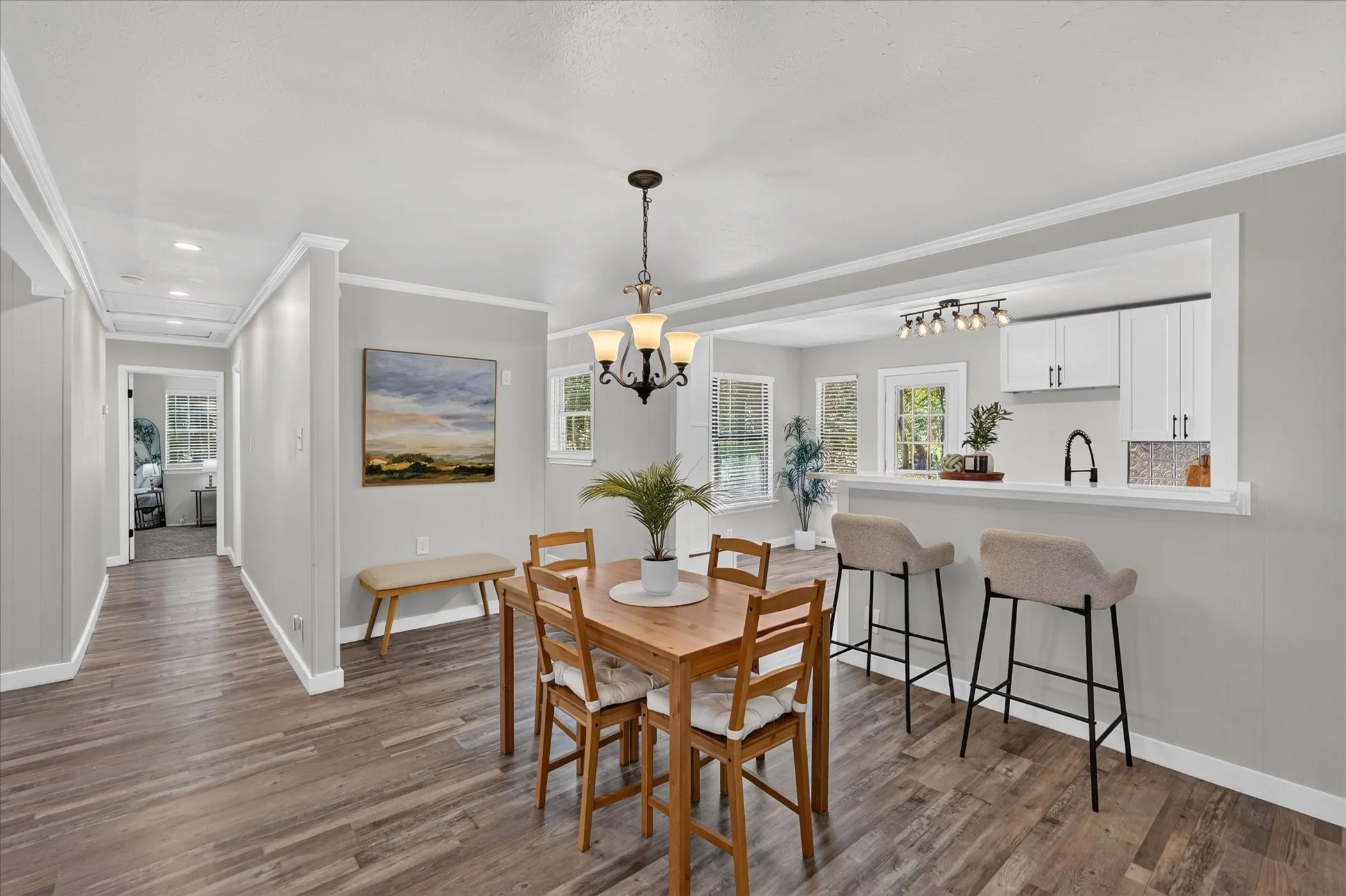 Wood-finish flooring throughout, white trim, and light gray wall paint