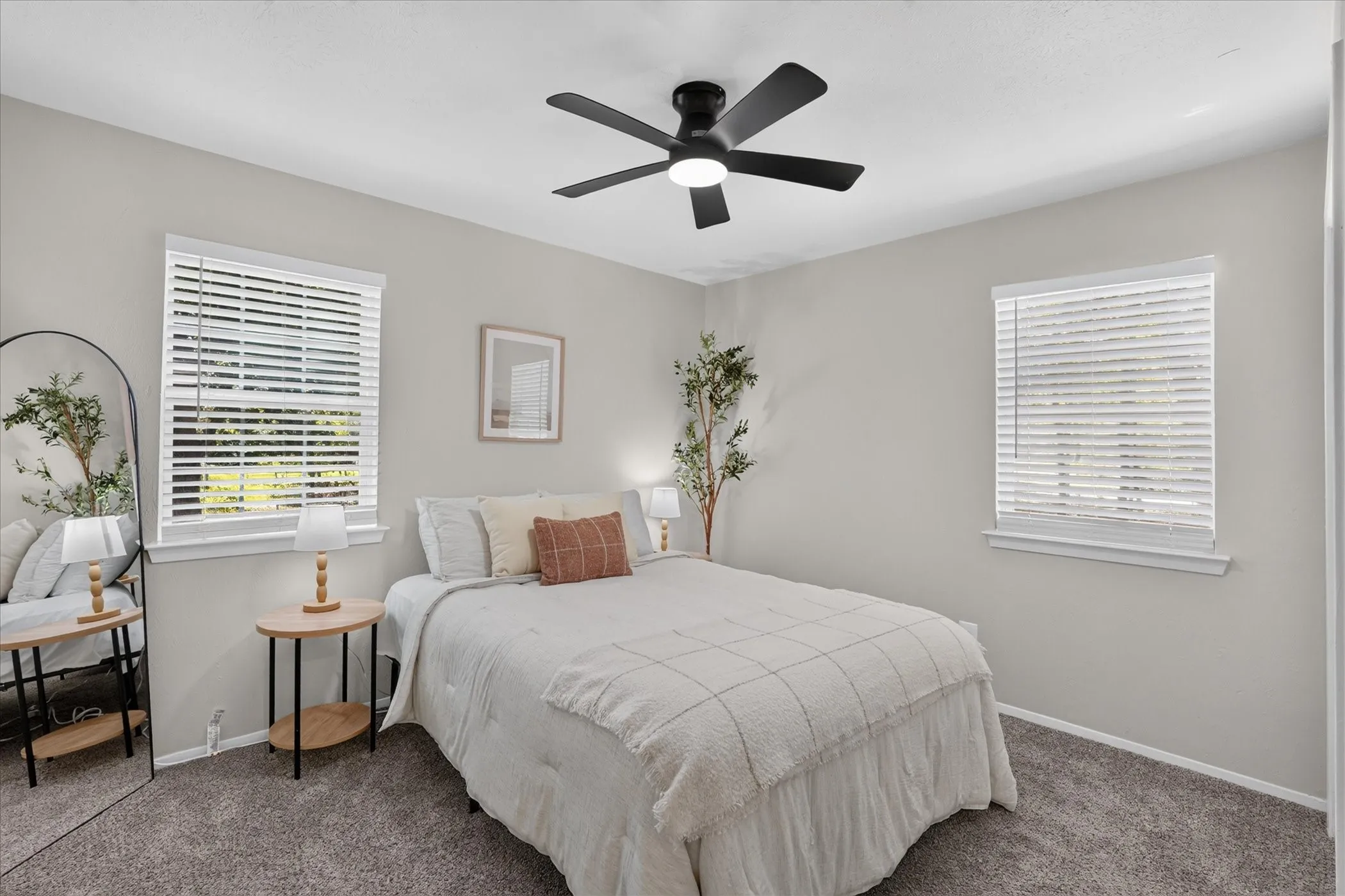 Gray wall color with white trim, a black ceiling fan, and gray carpet