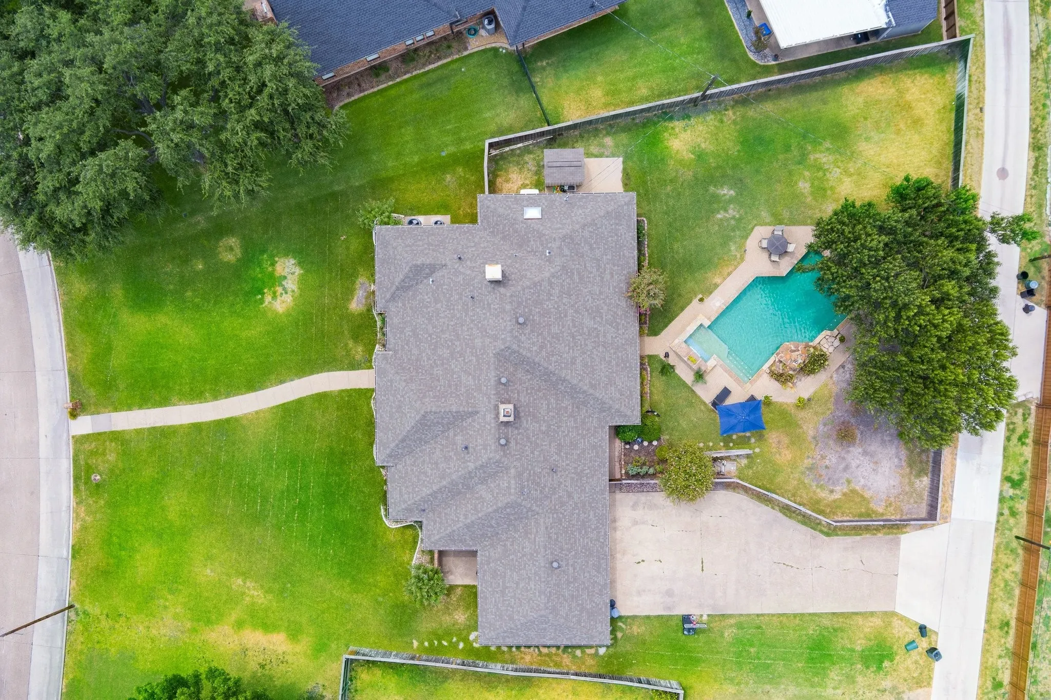 Expansive property featuring a large backyard with a swimming pool, concrete patio, and mature trees