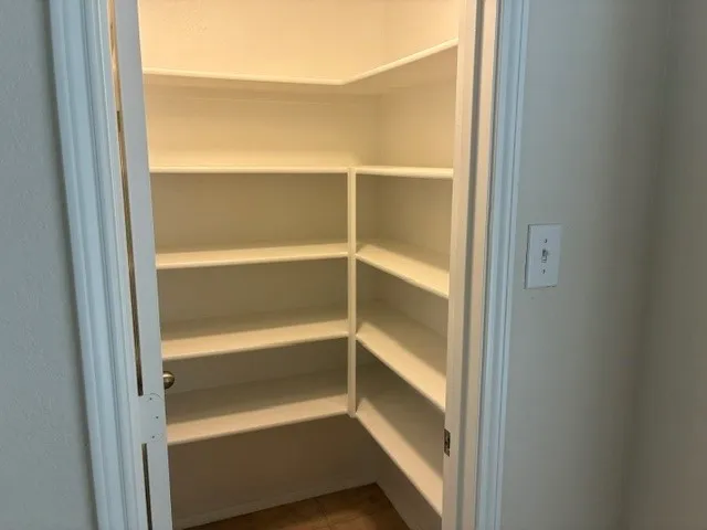 L-shaped pantry with multiple white built-in shelves