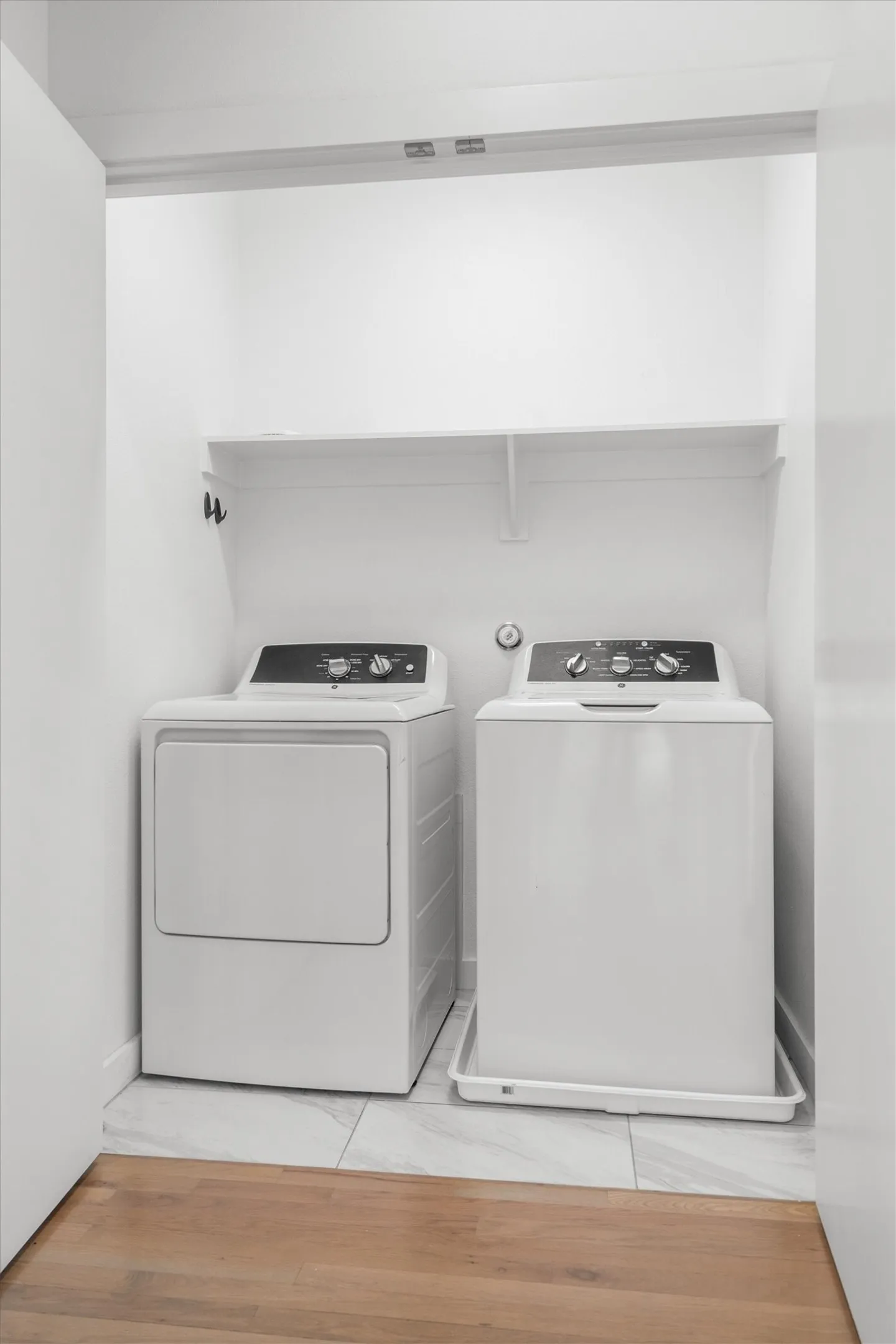 Laundry area featuring a top-load washer, a front-load dryer, and a built-in shelf