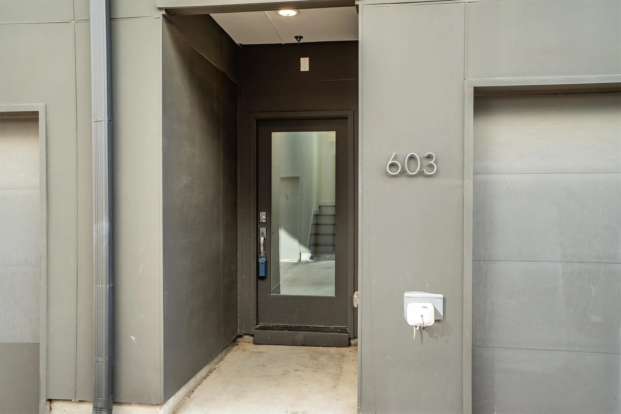 Modern exterior with full-lite entry door, recessed lighting, and clearly visible address numbers