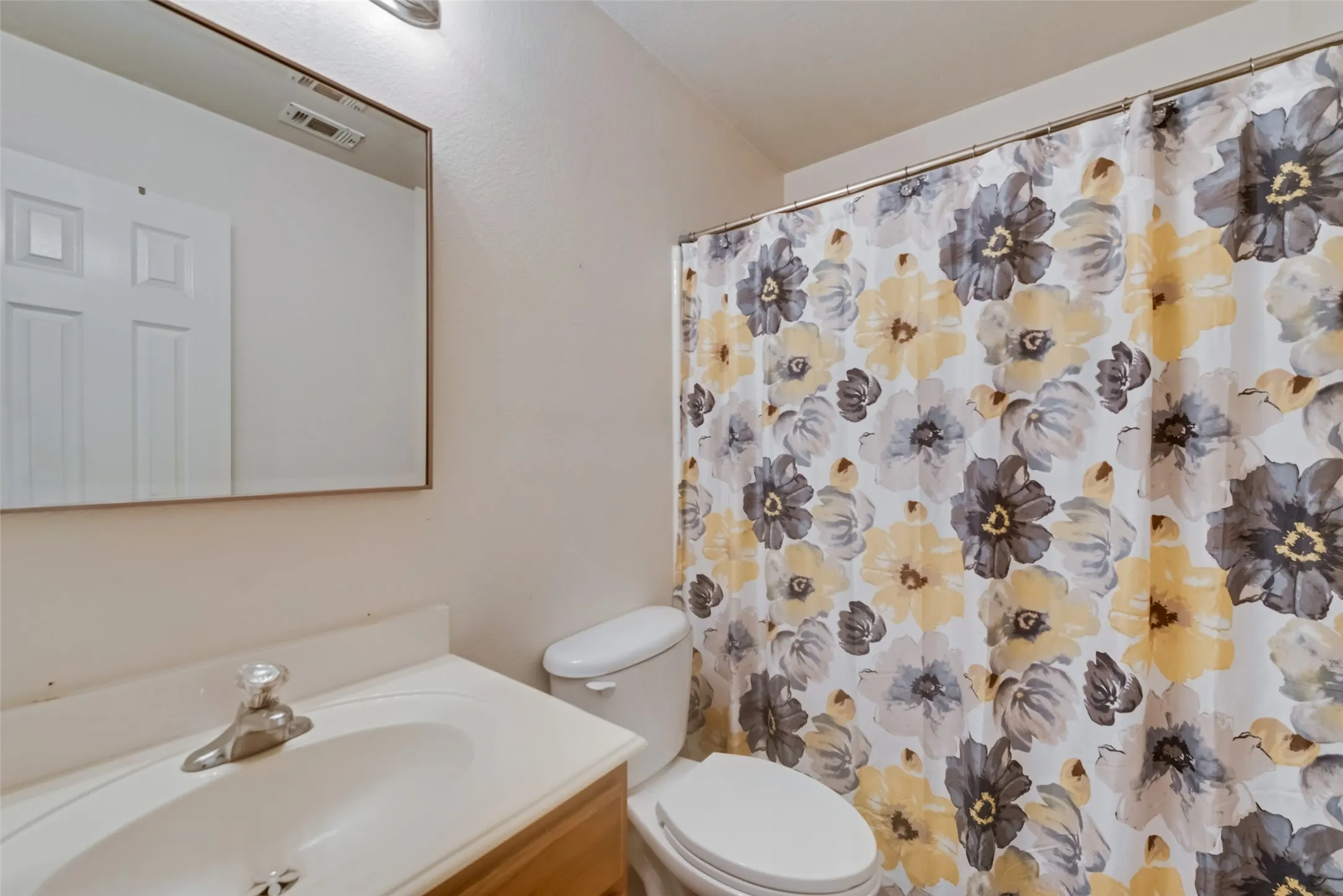 Vanity with integrated sink, chrome faucet, and rectangular wall mirror