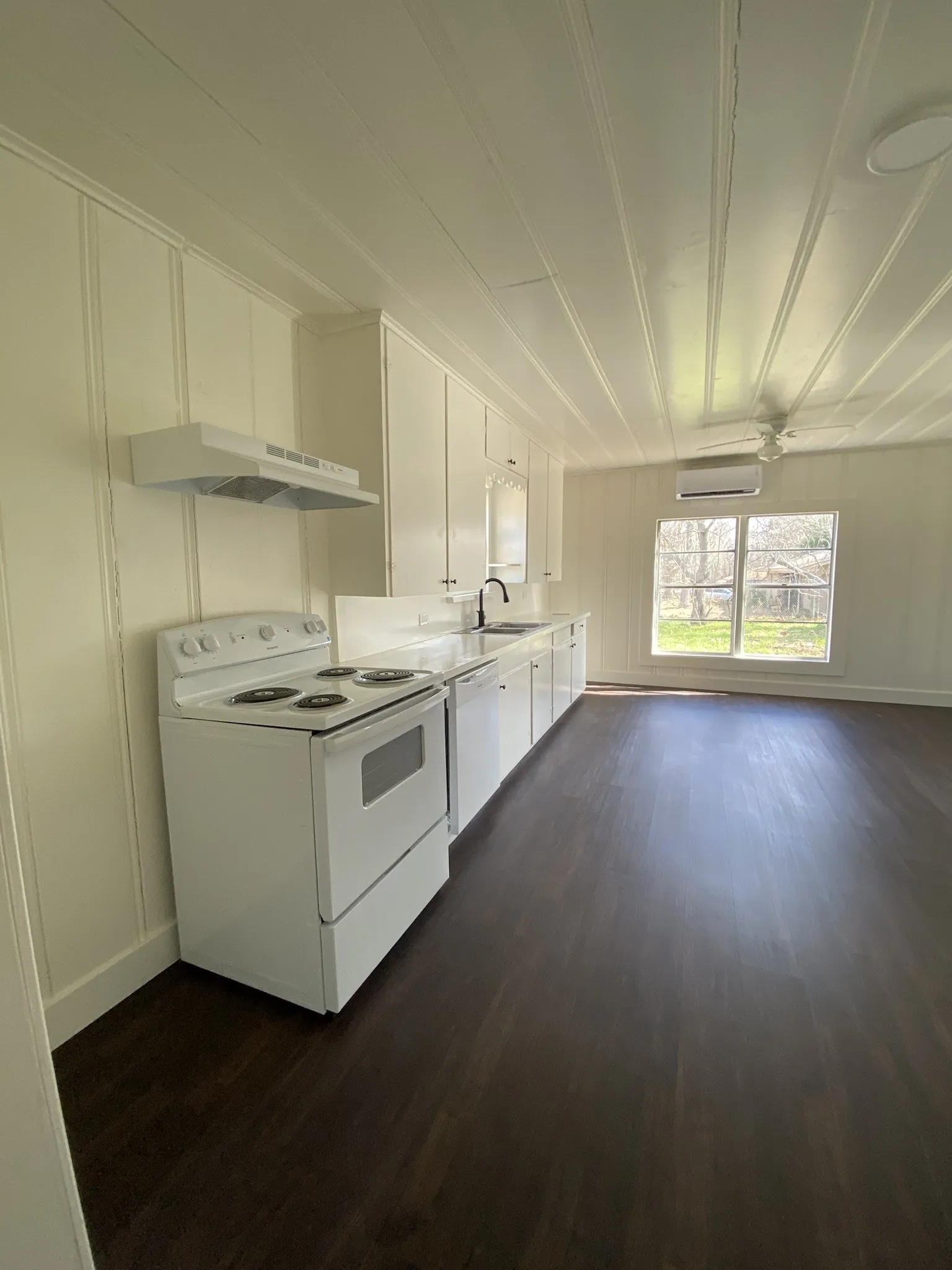 Dark wood-finish flooring, white cabinetry, white electric range, white range hood, and a ceiling-mounted fan
