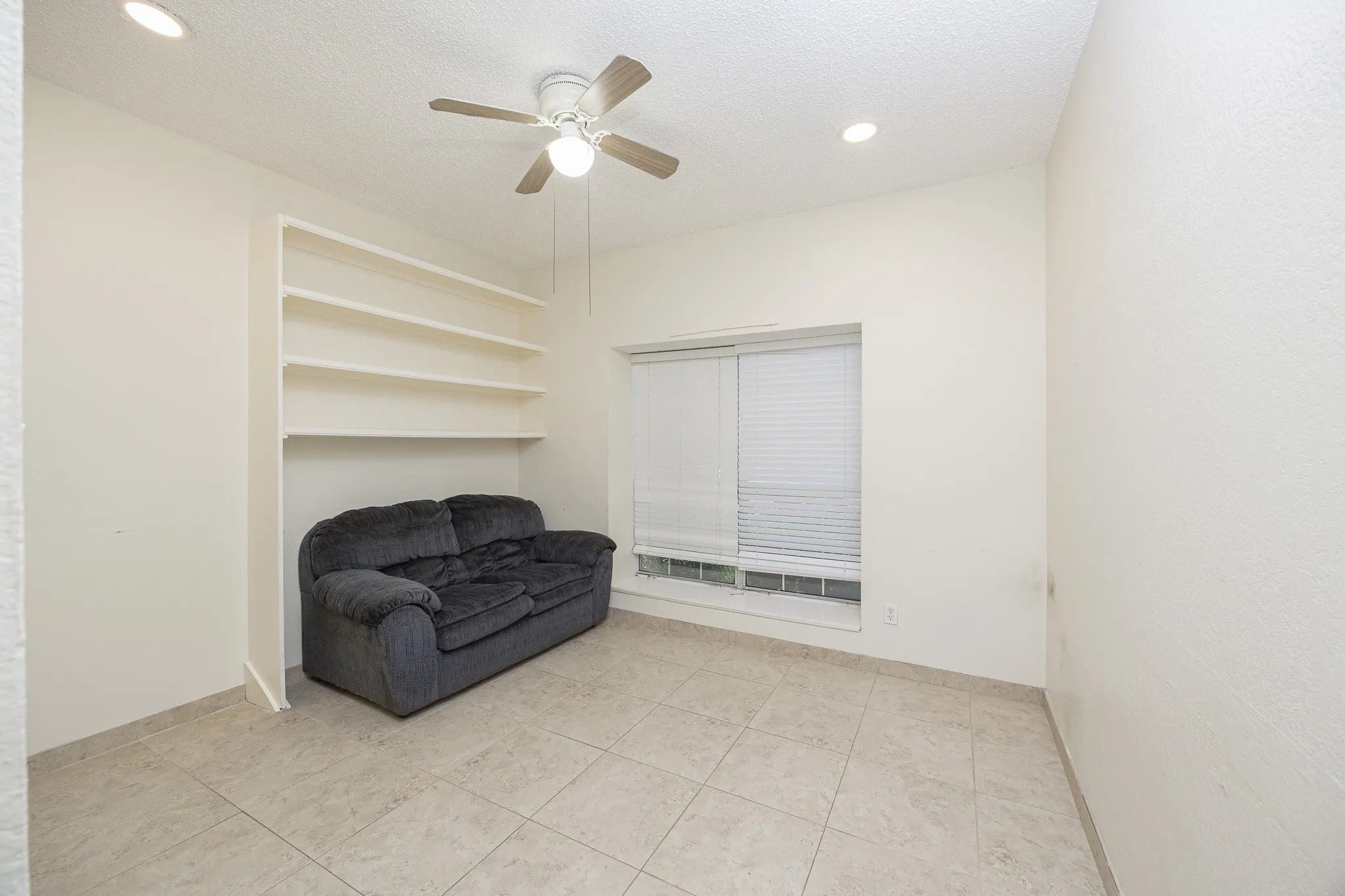 Tile flooring, recessed lighting, built-in shelving, window with blinds, and ceiling fan with light fixture