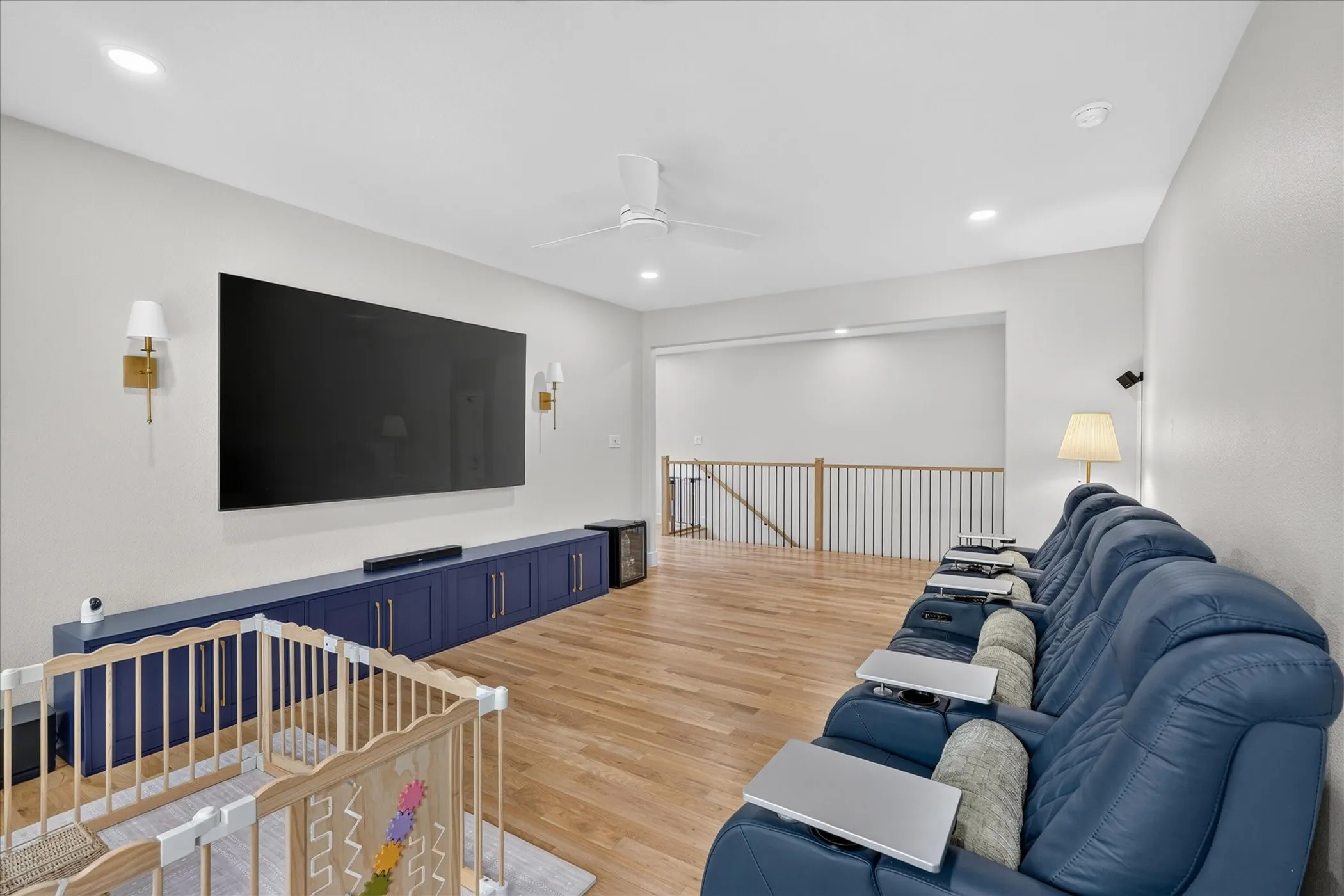 Hardwood-style flooring, recessed lighting, ceiling fan, built-in cabinetry, and wall sconces