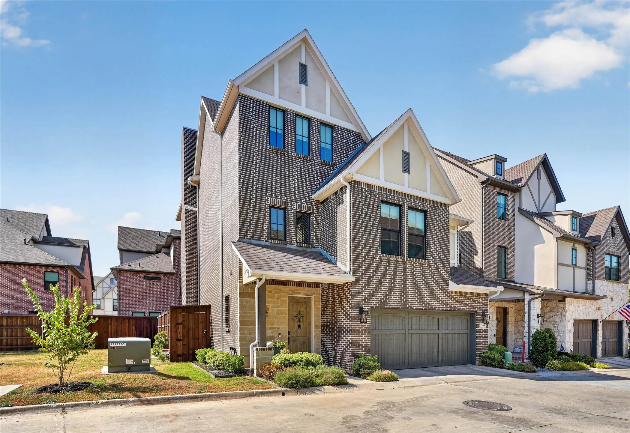 Brick exterior with gabled roof lines, attached garage, and stone accents