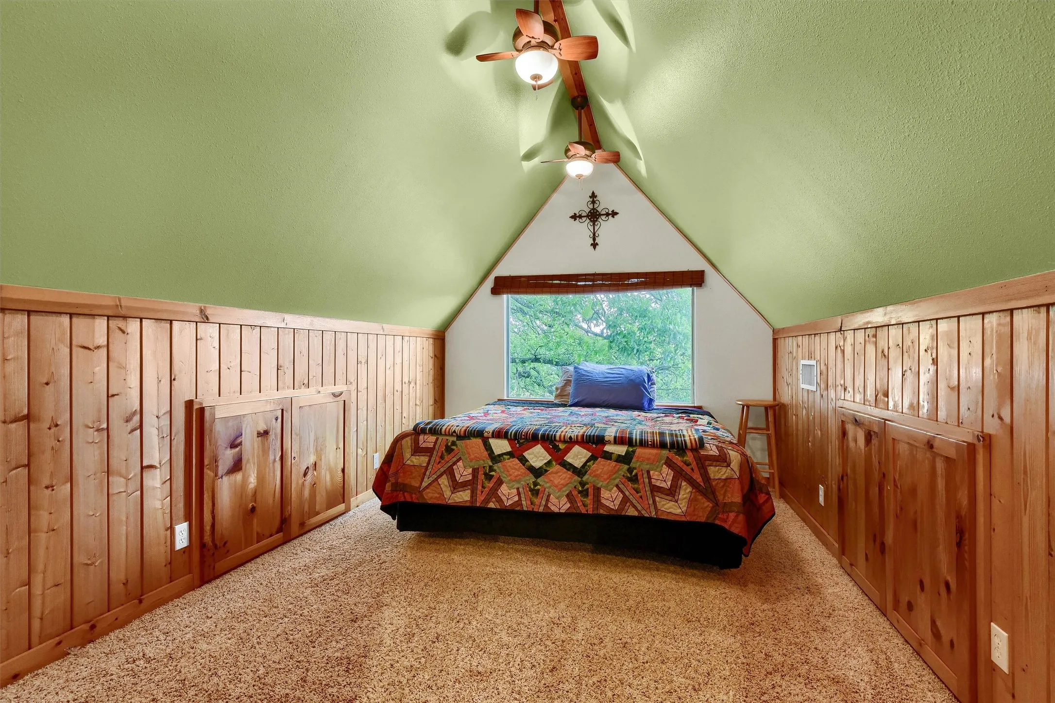 Carpeted bedroom featuring wood walls, ceiling fan, a textured ceiling, and lofted ceiling