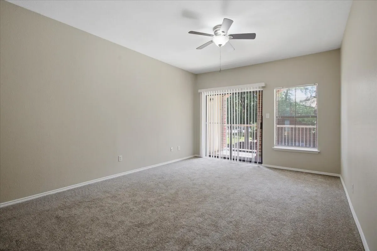 Living room with sliding glass door to the patio (unstaged)