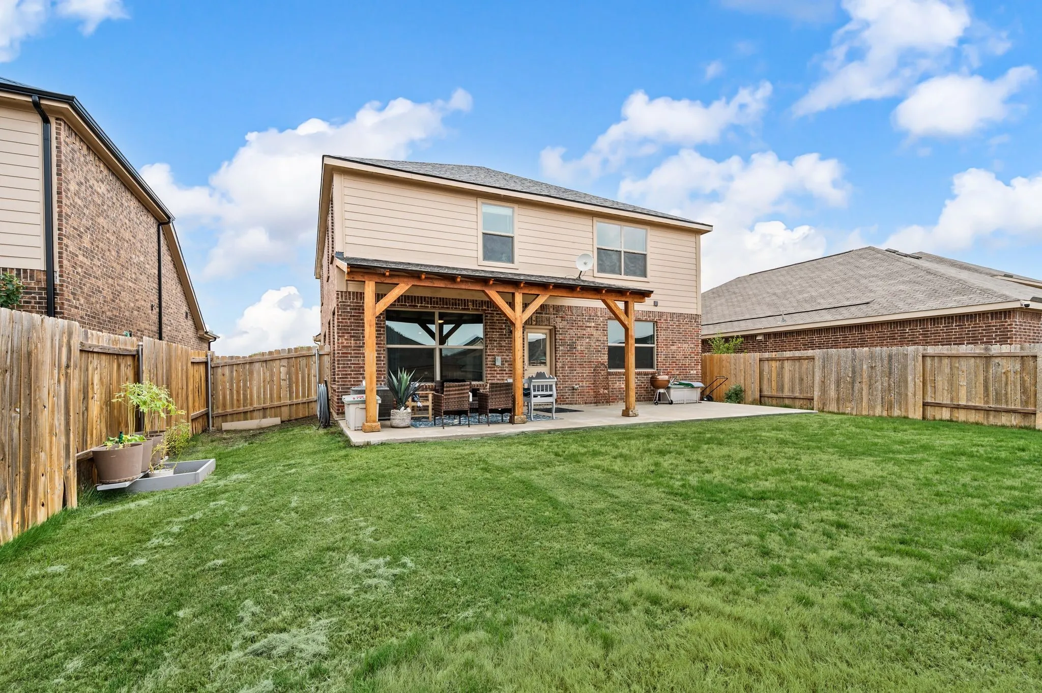 Expansive green lawn with a full wood fence