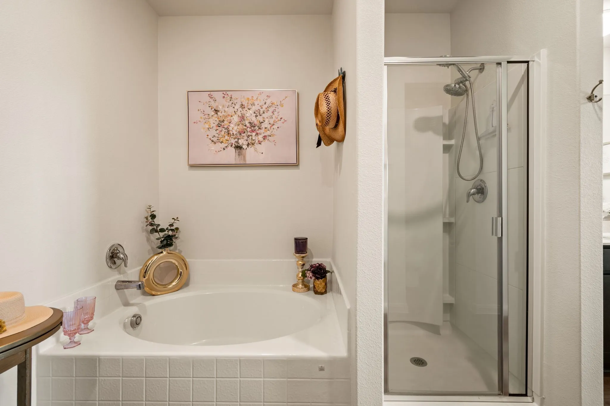 Built-in soaking tub with tile surround, separate shower with glass enclosure, and white wall finishes