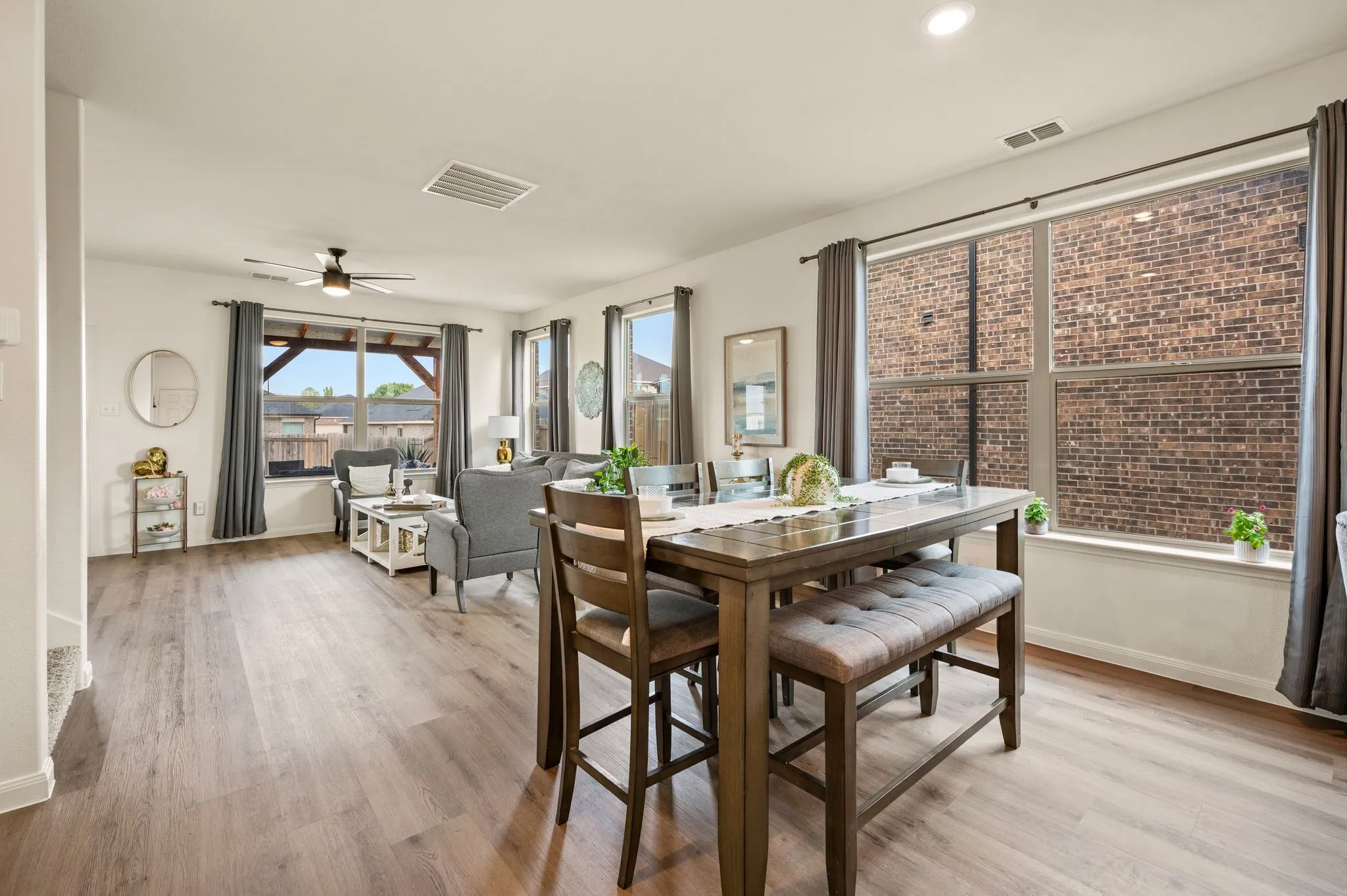 Open-concept living area with wood-finish flooring, recessed lighting, and multiple windows