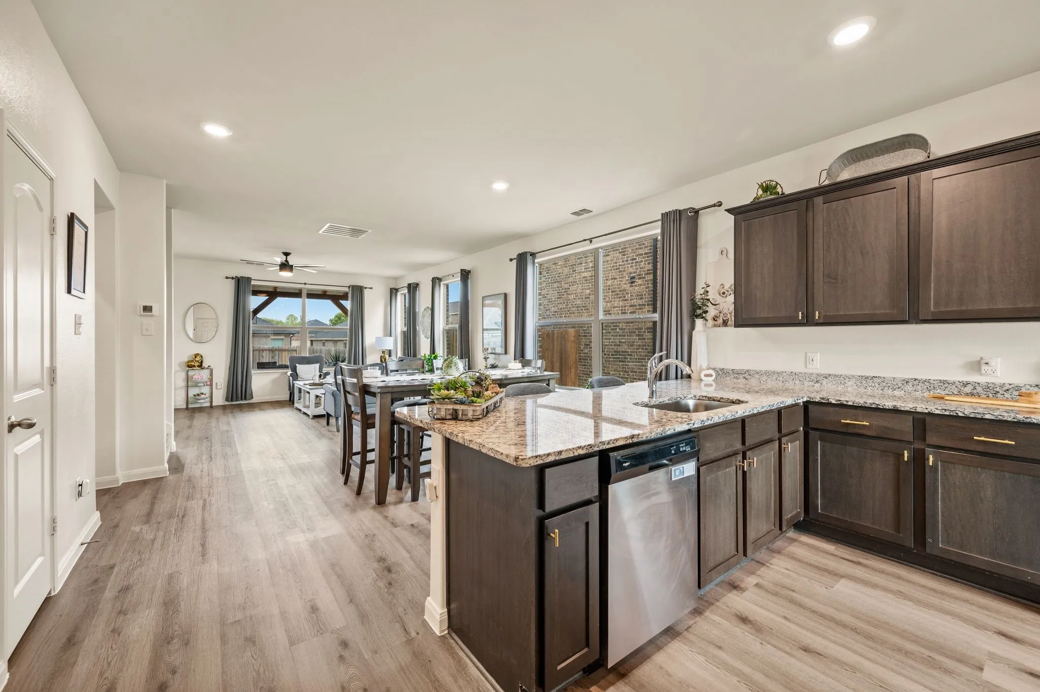 Open-concept living space with wood-finish flooring, recessed lighting, and a ceiling fan