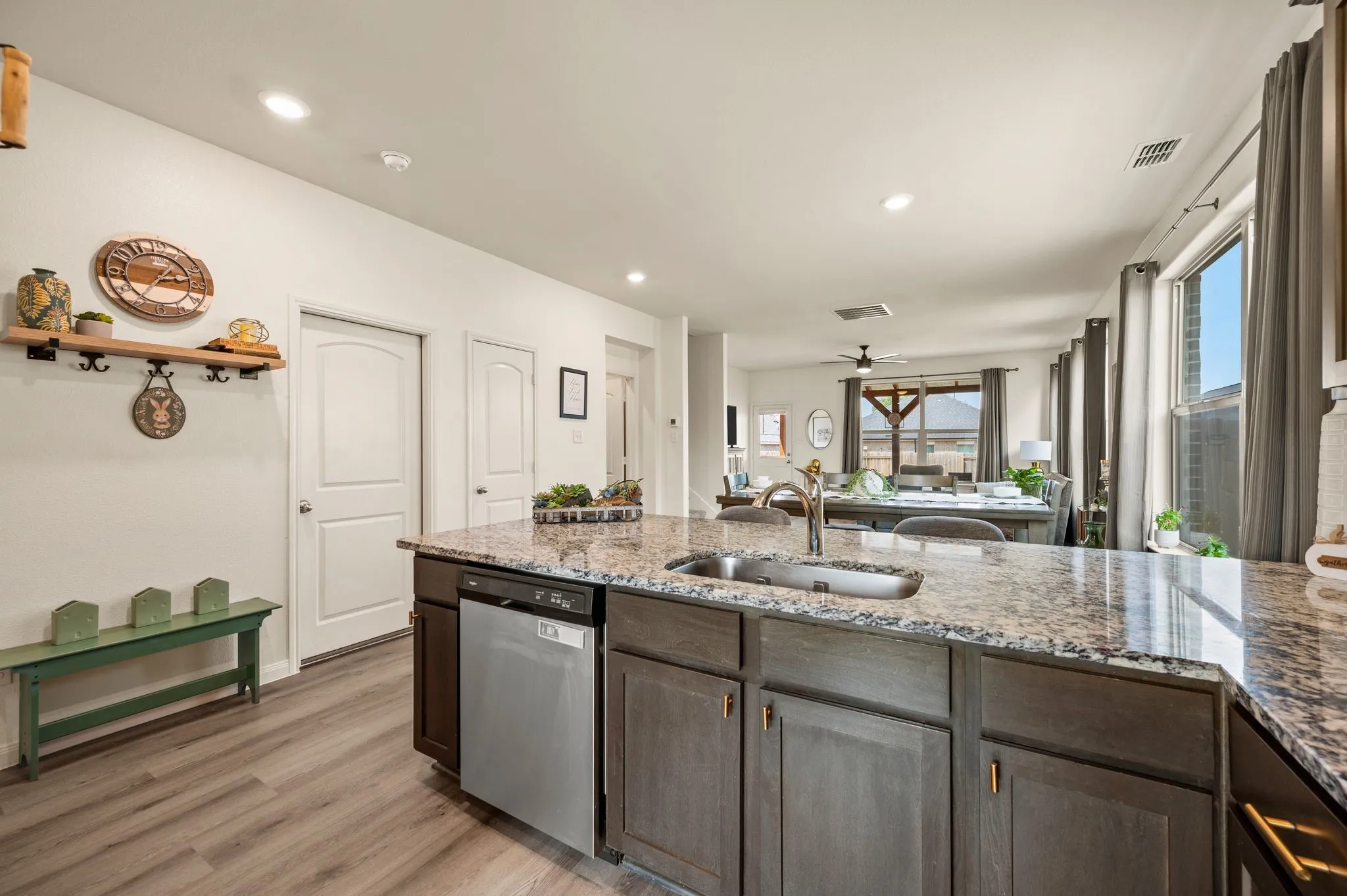 Spacious kitchen island featuring a stainless steel sink, a stainless steel dishwasher, and a granite countertop