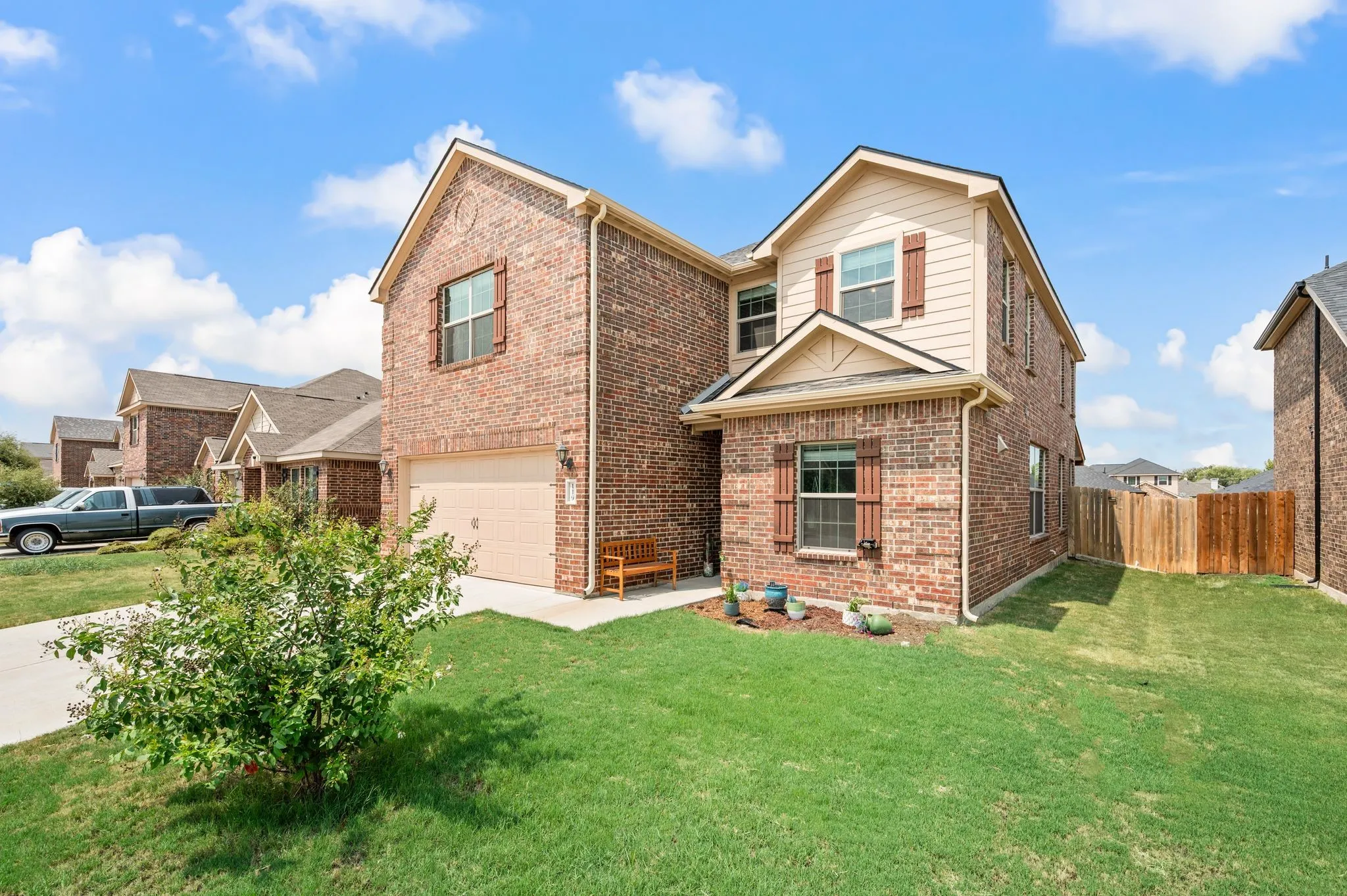 Brick facade with siding accents, attached garage and a fenced yard