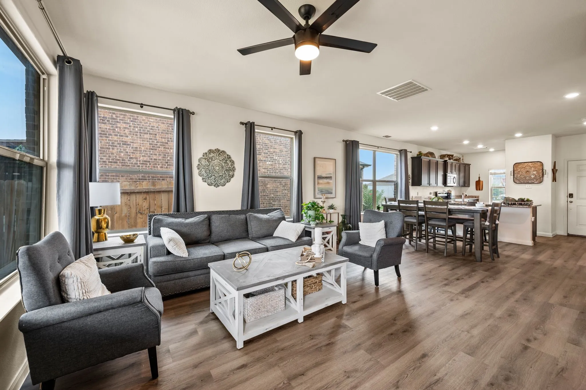 Spacious open-concept living area featuring wood-finish flooring, recessed lighting, and a ceiling fan