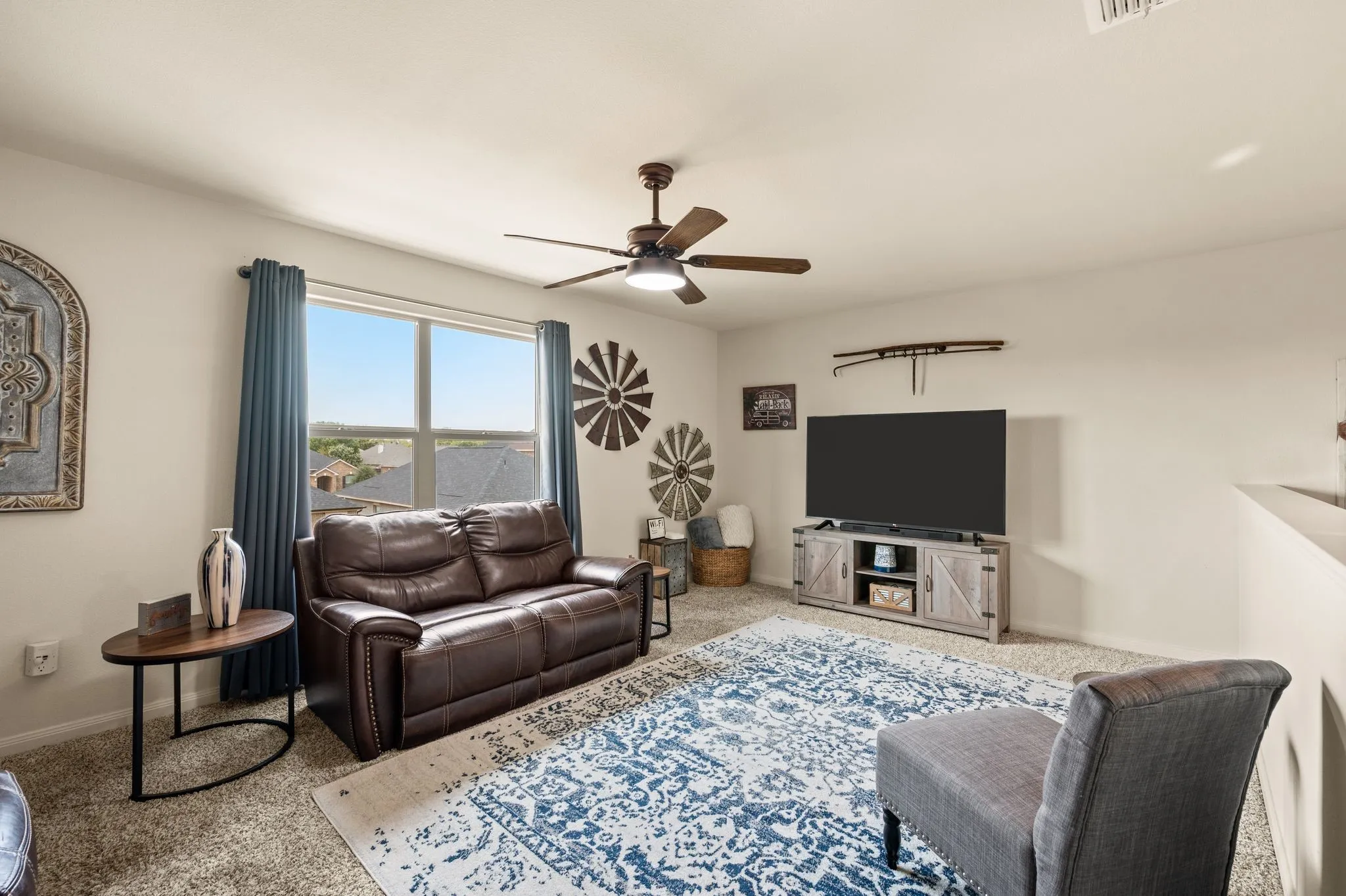 Carpeted room with a ceiling fan, and window
