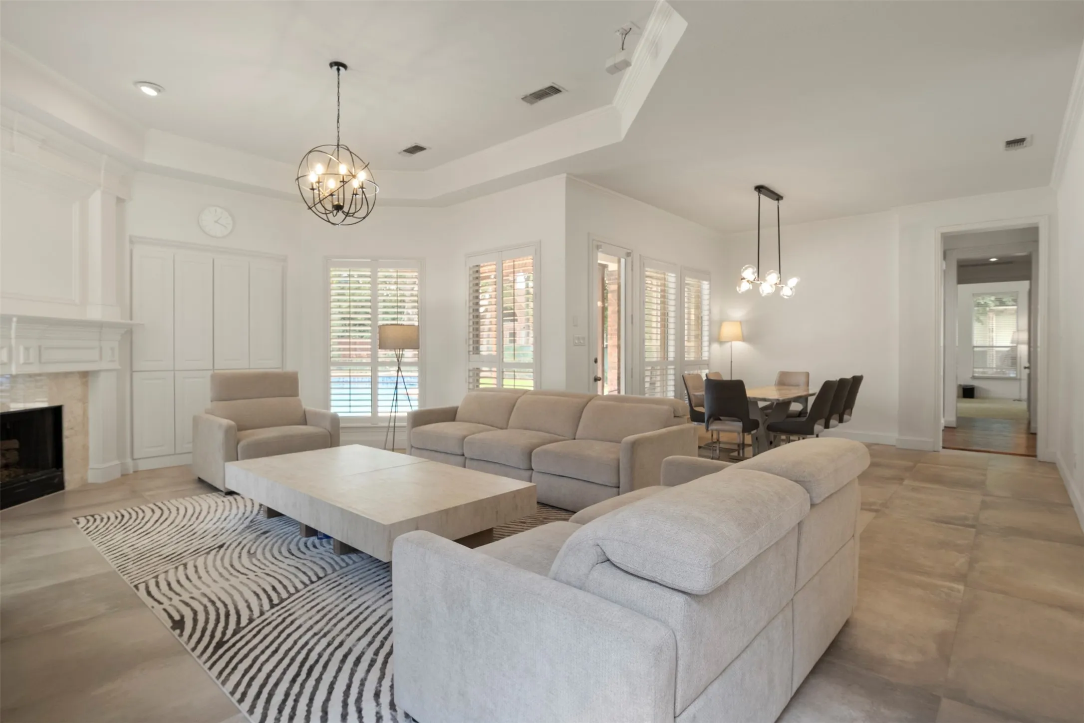 Spacious living area featuring a fireplace with a mantel, built-in cabinetry, and tile flooring