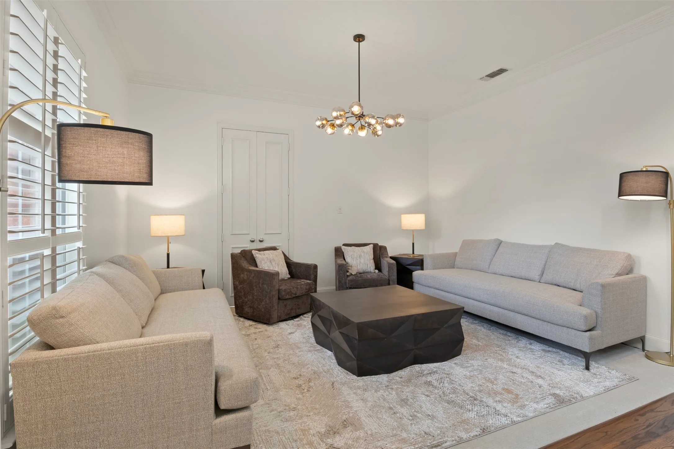 White walls, crown molding, and wood-finish flooring