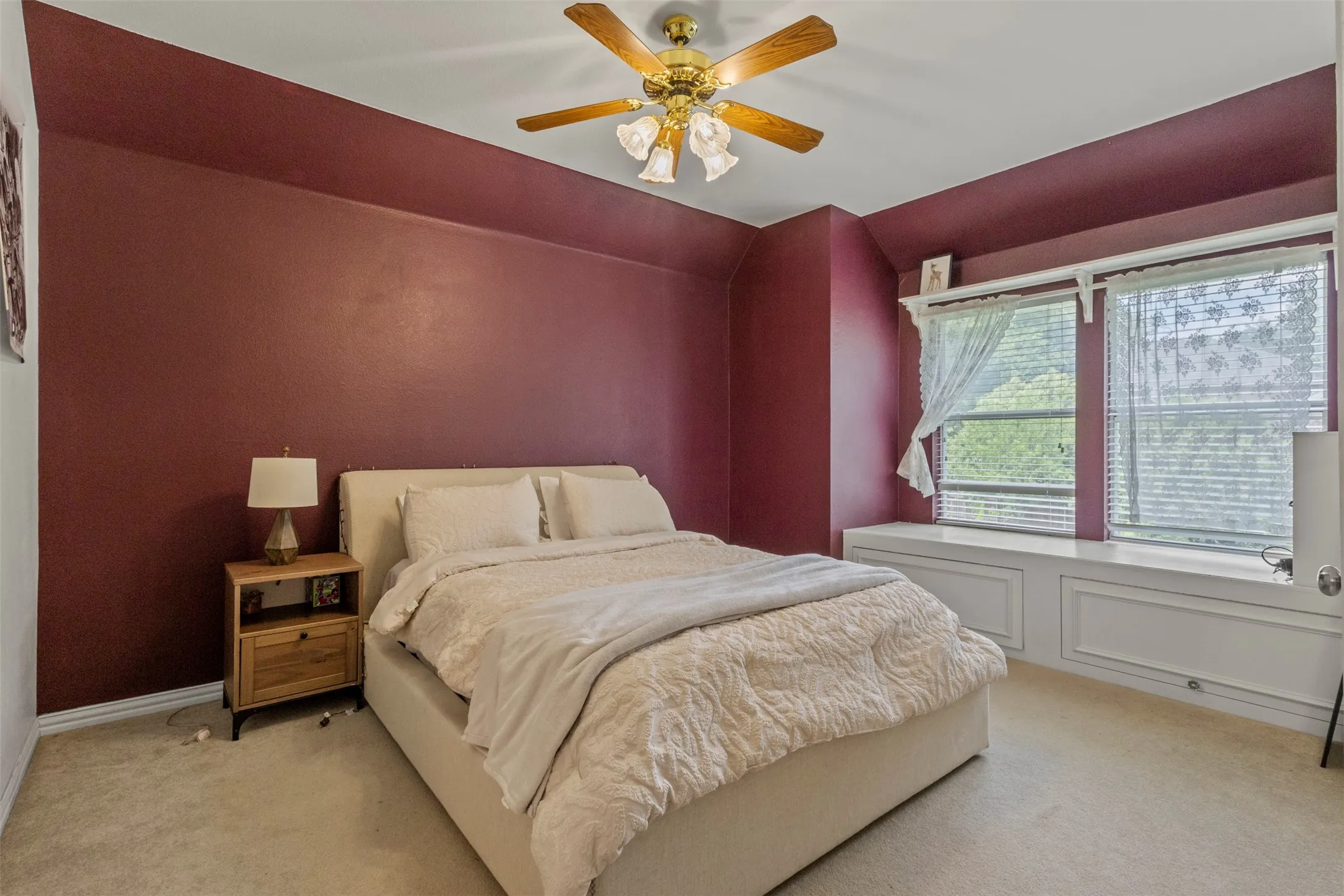 Ceiling fan with light fixture, dual windows, built-in window seating, and wall shelving