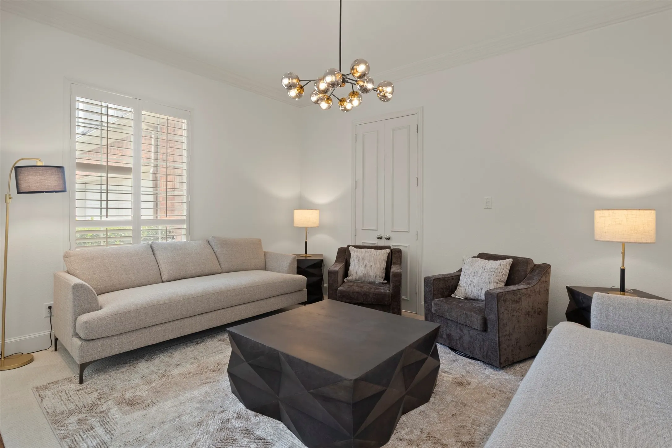 White walls with crown molding, plantation shutters, and a contemporary chandelier
