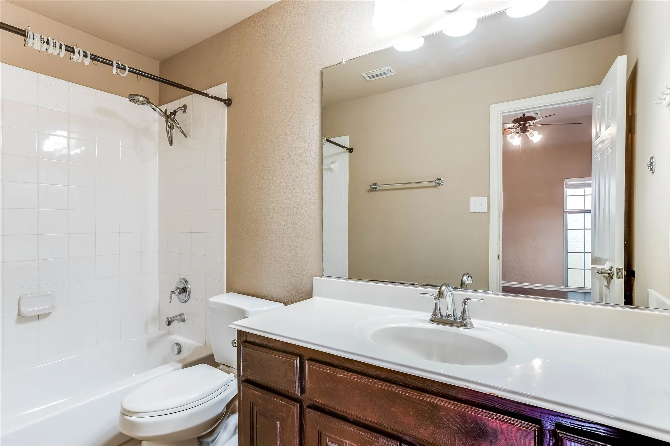 White tile shower surround with a chrome shower head and faucet