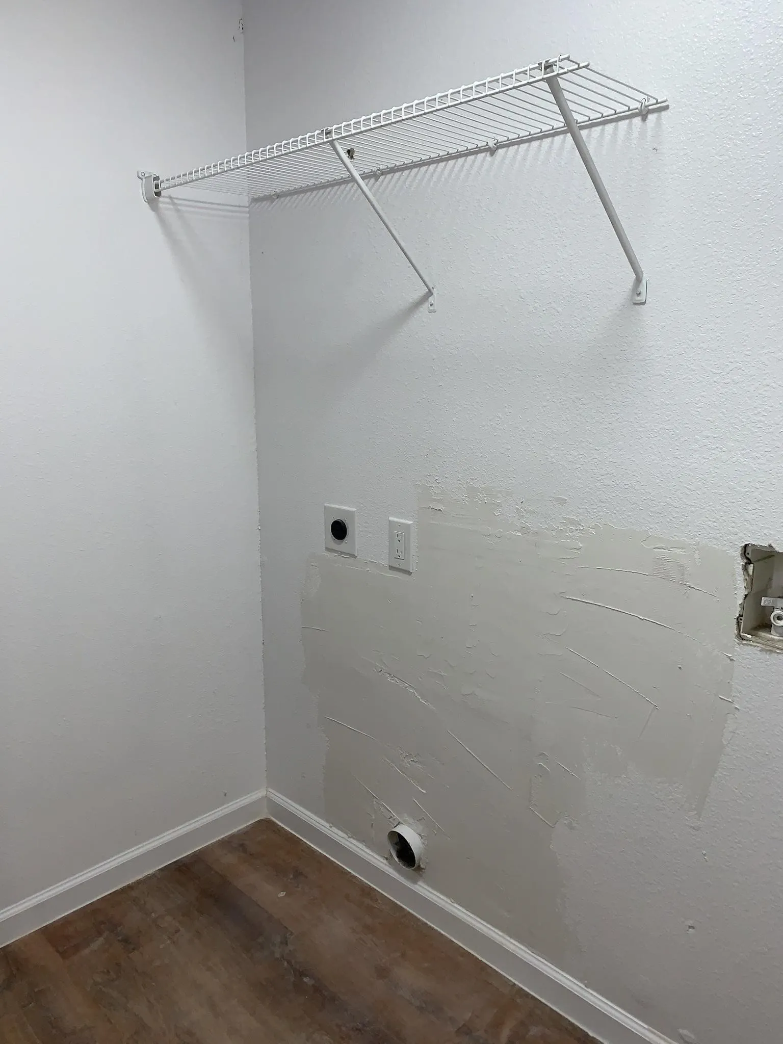 Wire shelving, wood-finish flooring, and white painted walls