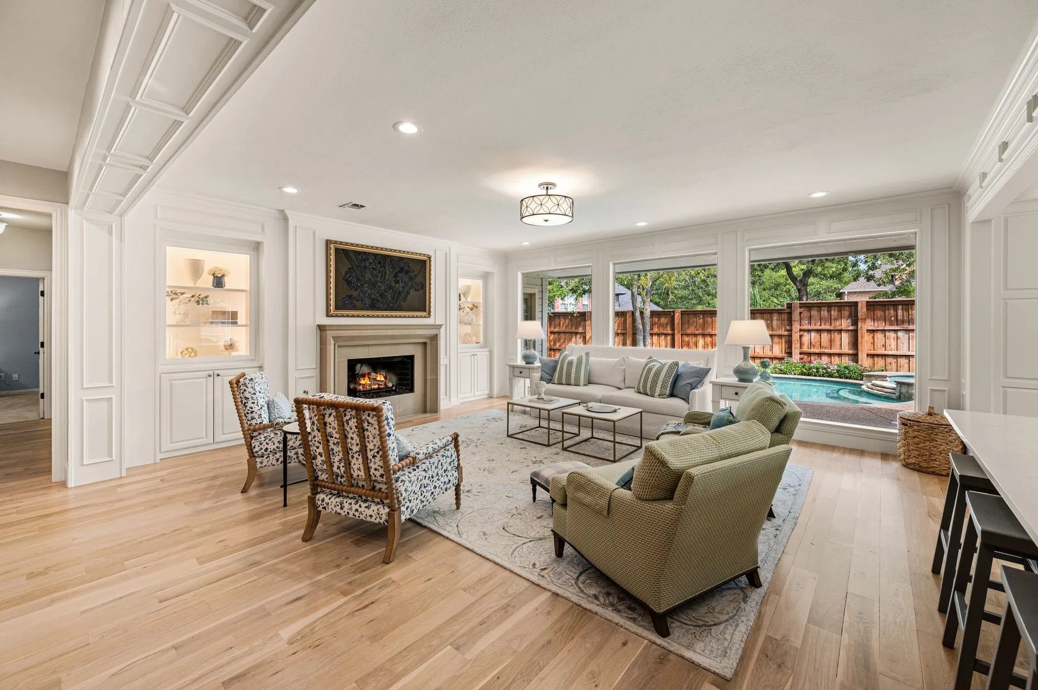 Floor-to-ceiling windows frame the pool from the living room, bringing the backyard into view and filling the space with natural light.