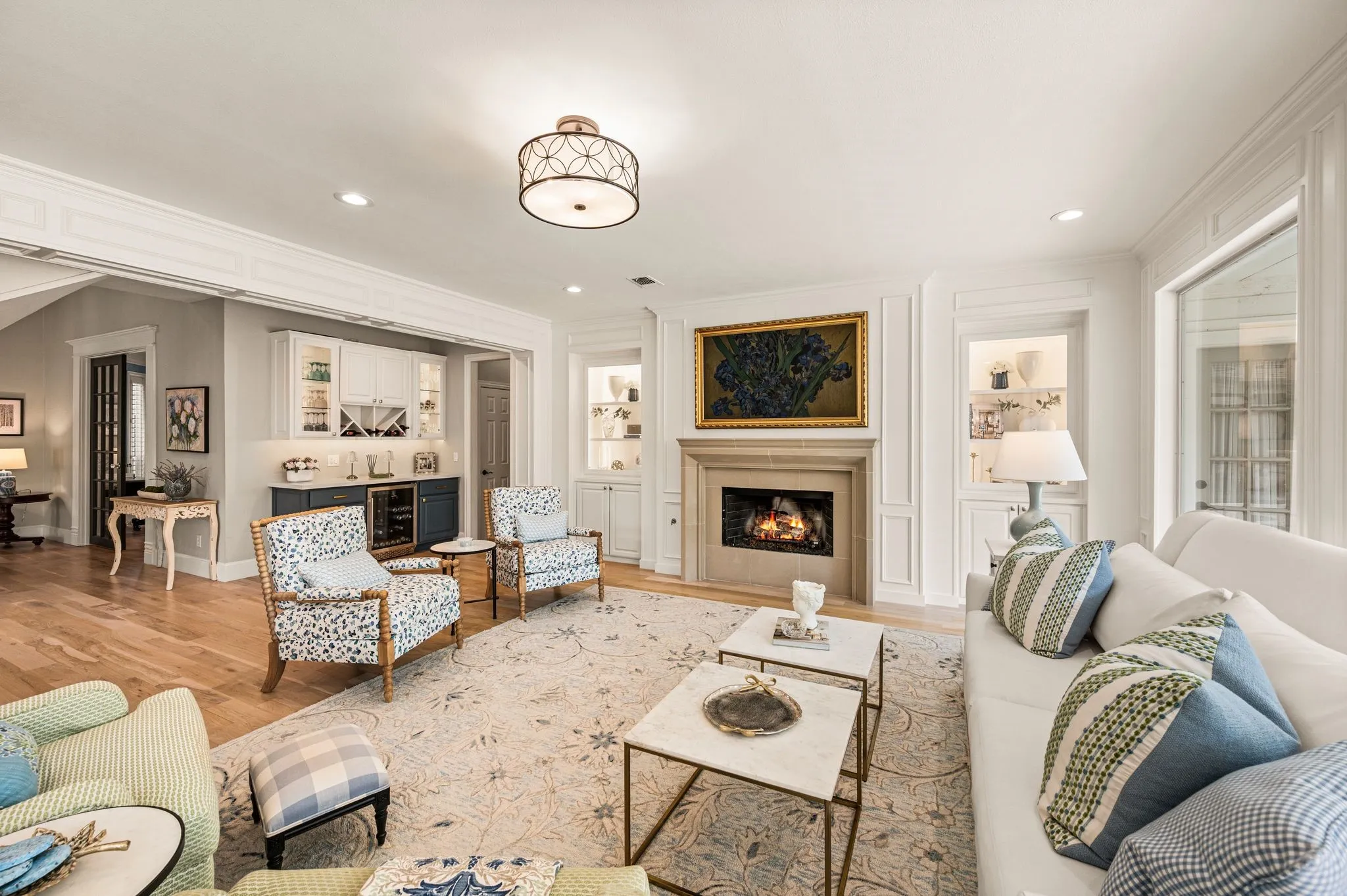 A fireplace, illuminated built-ins and a tucked-away bar add warmth and character to a living space designed for both everyday life and a house full of people.
