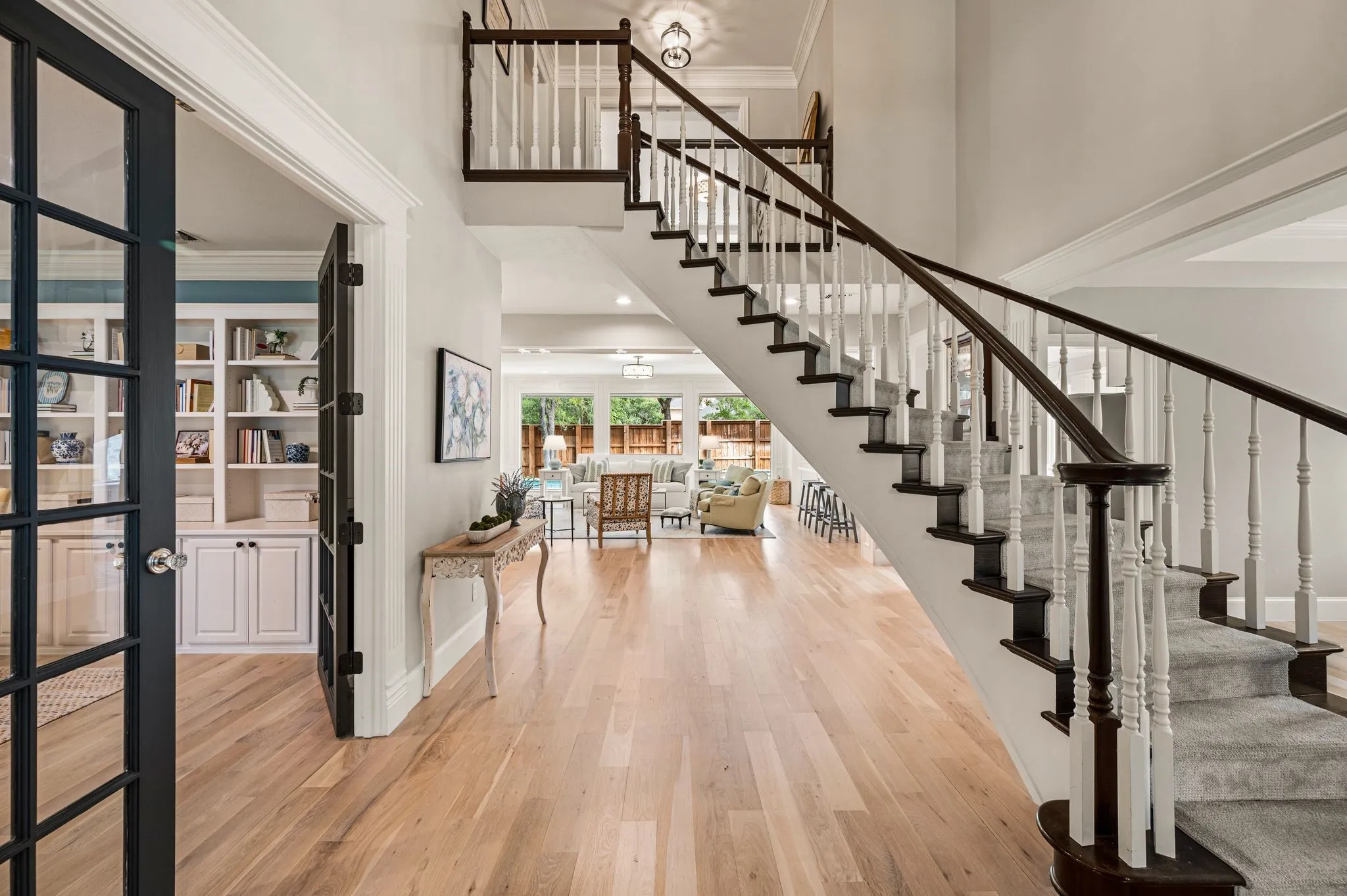 From the entry, the home begins to unfold toward the main living spaces, with the staircase and millwork providing a sense of architecture and continuity throughout.