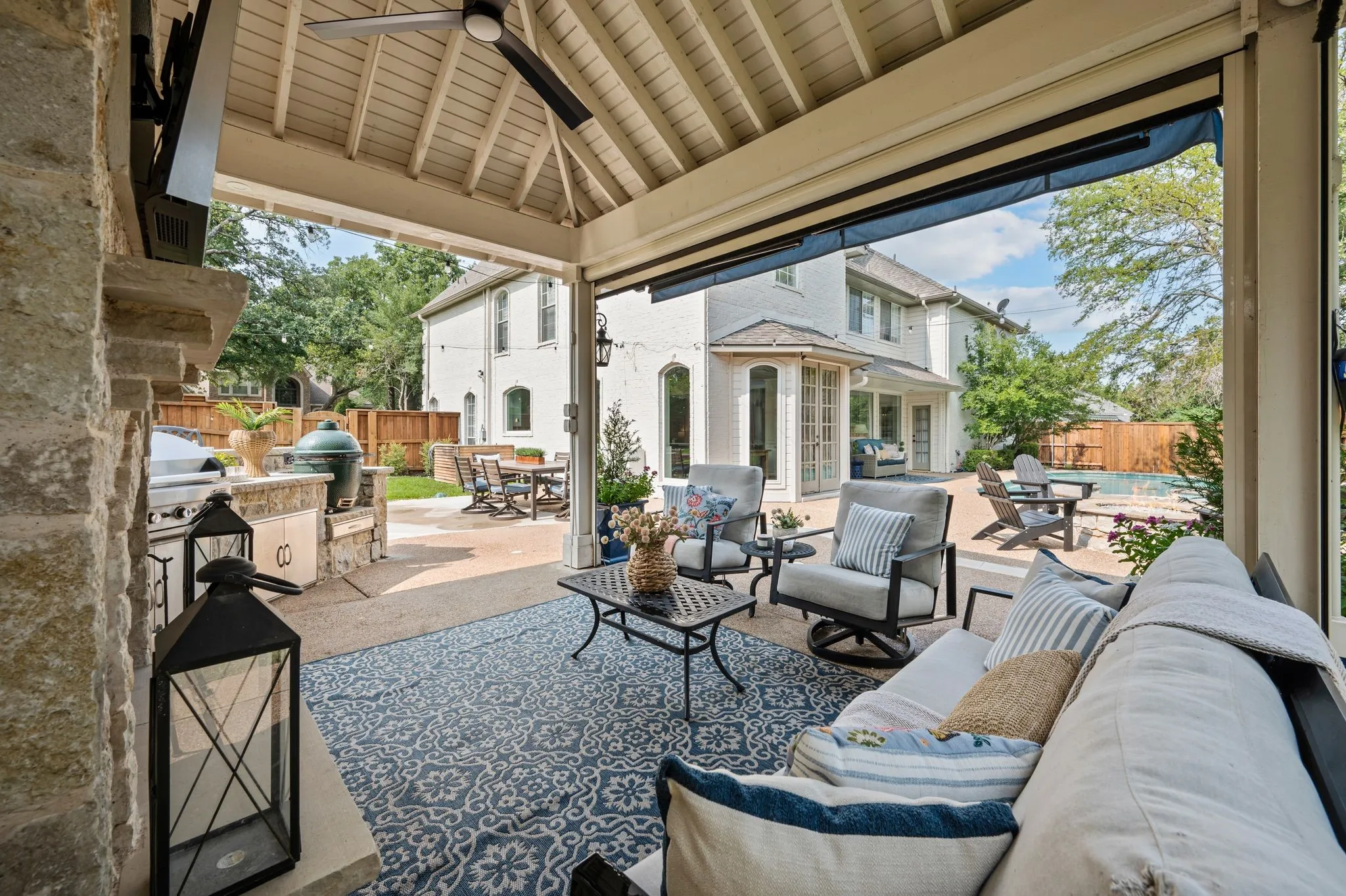 From the outdoor living, the entire backyard comes into view, connecting the outdoor living area to the pool, fire pit and the home beyond.
