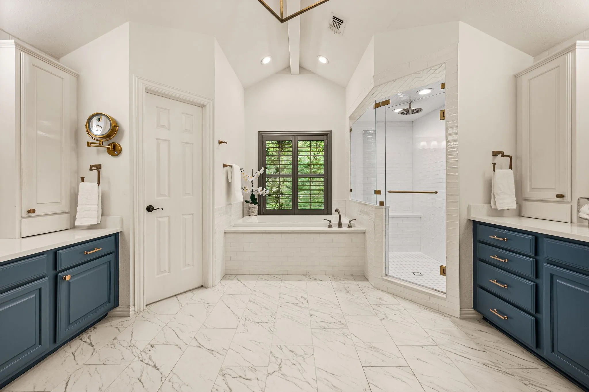 The owner's bath has been completely refreshed with marble-look flooring, dual vanities, a soaking tub and an oversized glass-enclosed shower.