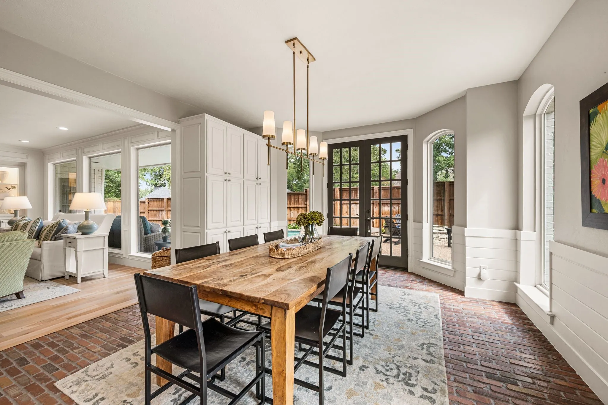 Surrounded by windows and French doors, the breakfast room feels almost garden-like, with brick floors adding another layer of warmth.