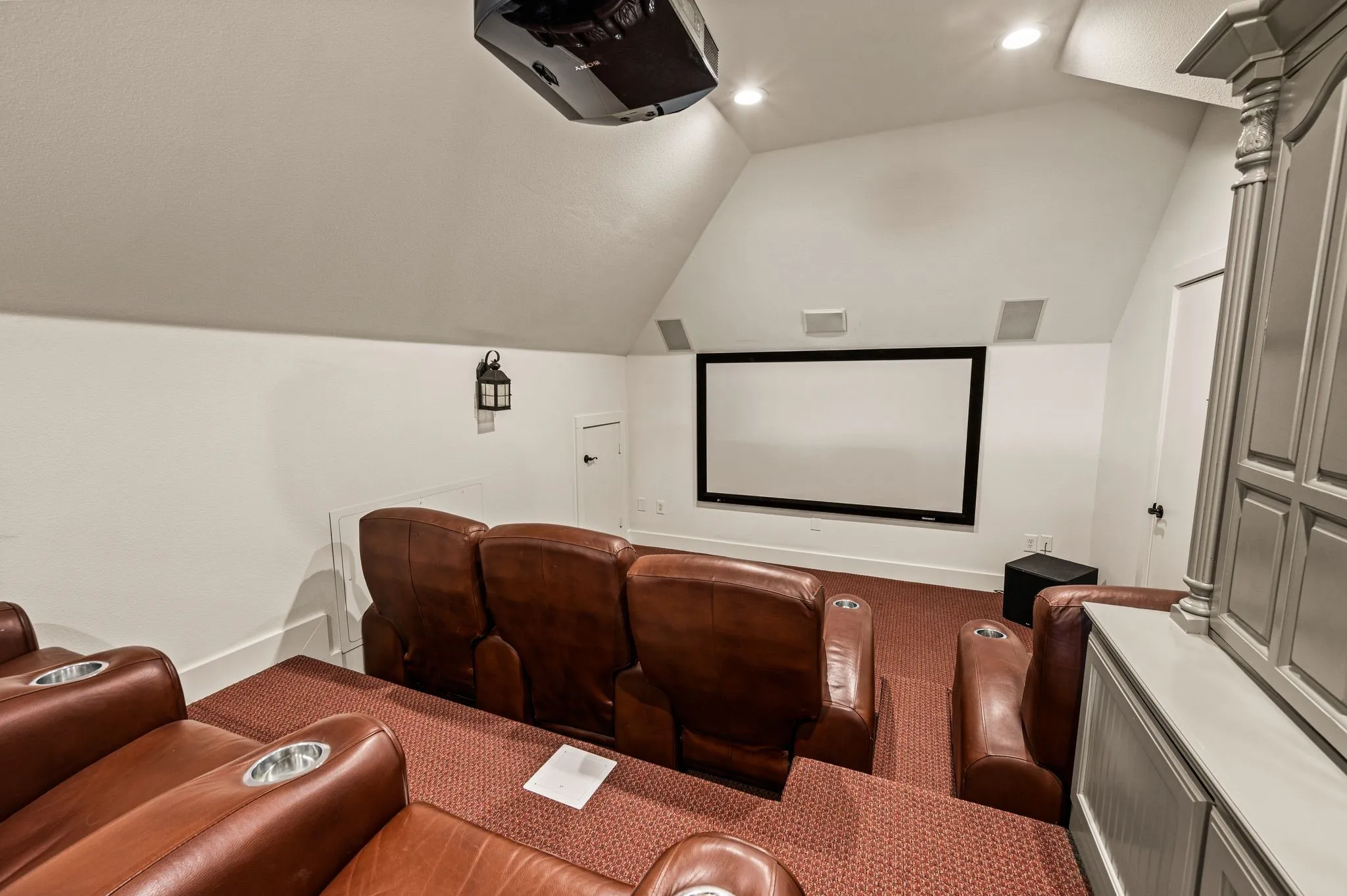 Just beyond the game room, the media room creates a dedicated place for movie nights, complete with theater seating and a large projection screen.