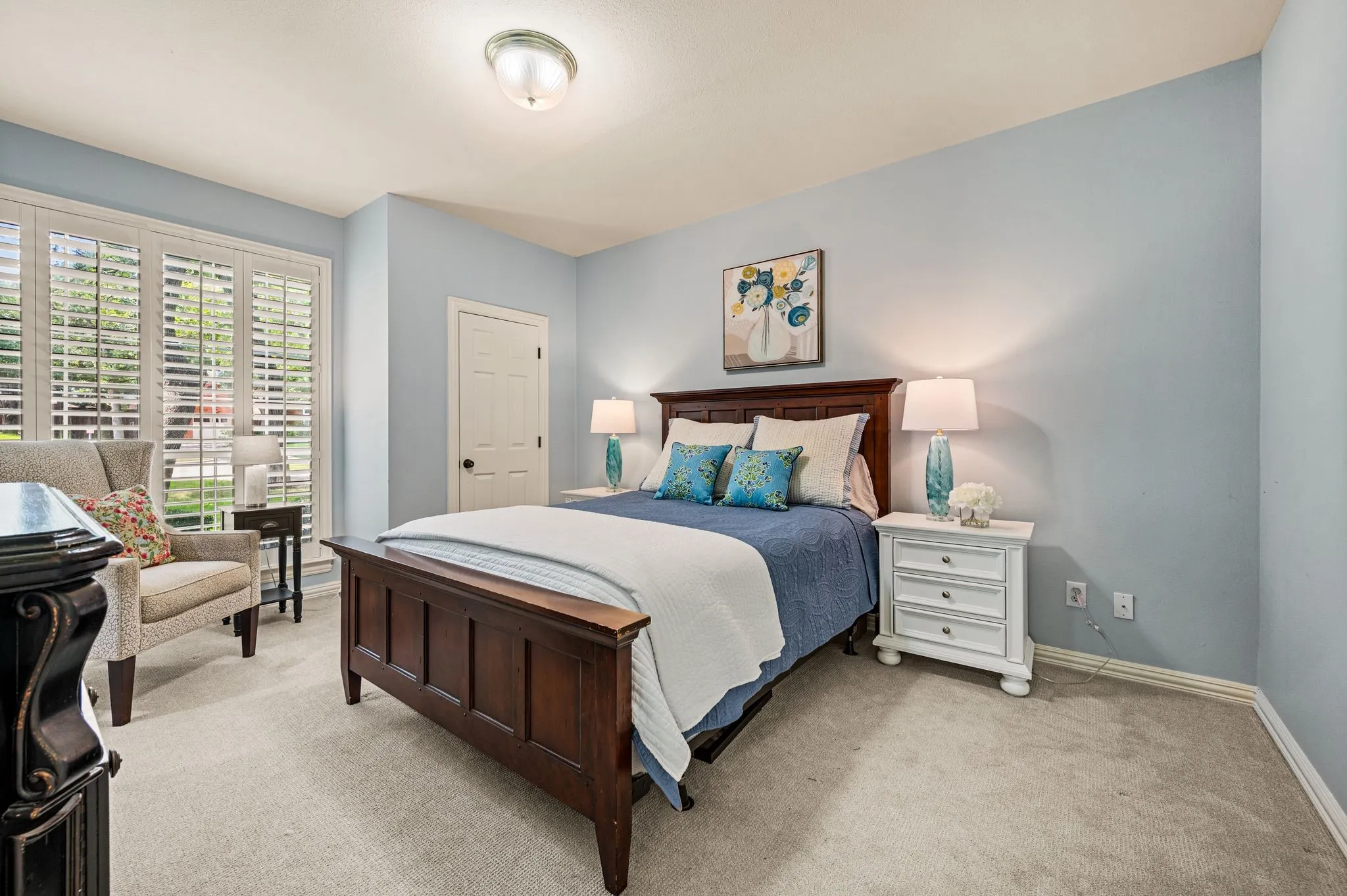 A secondary bedroom offers generous proportions, soft natural light and a calm palette that feels comfortable and private