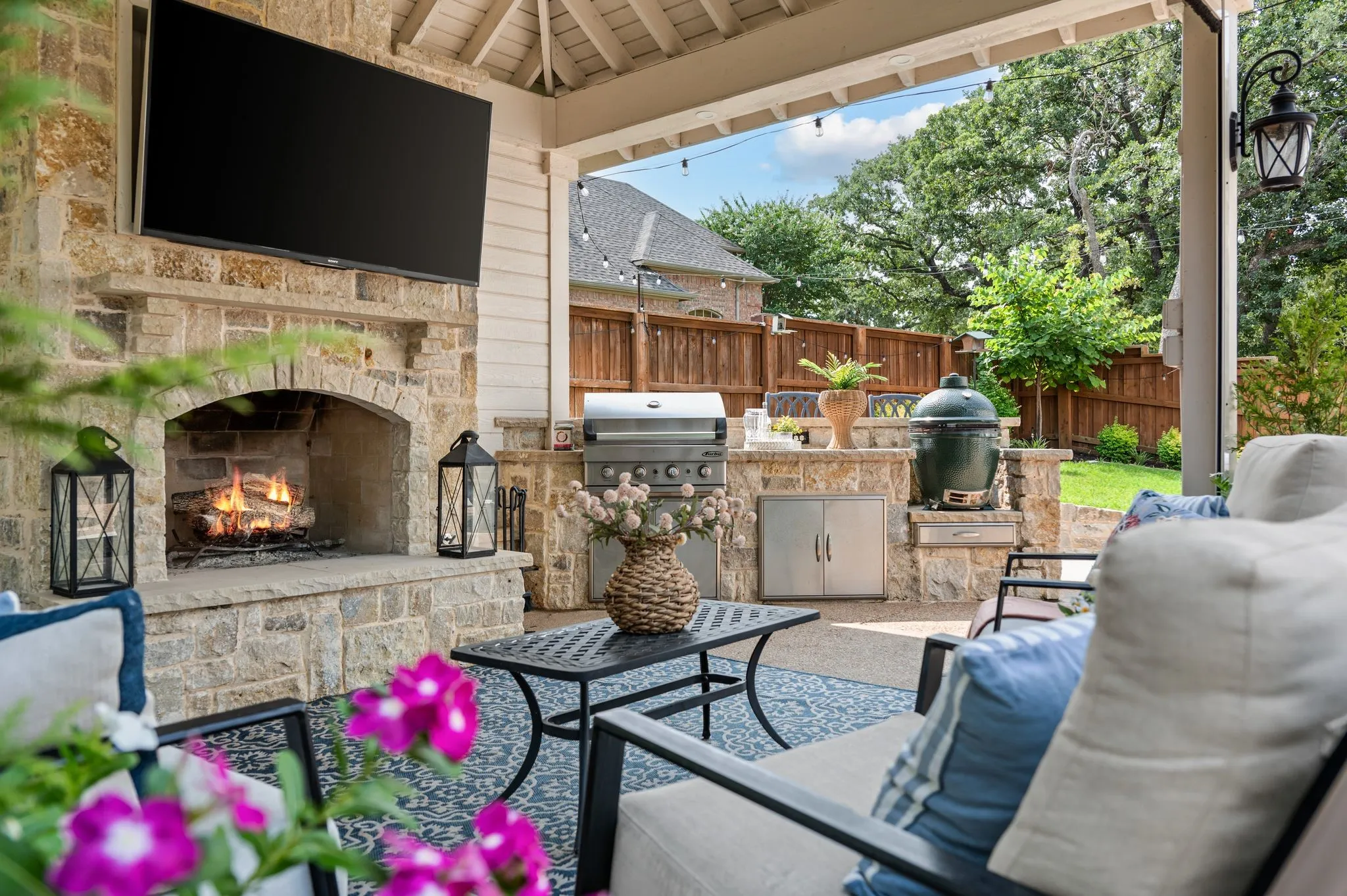 The covered outdoor living space adds another room to the home, complete with a fireplace, television and built-in grill.